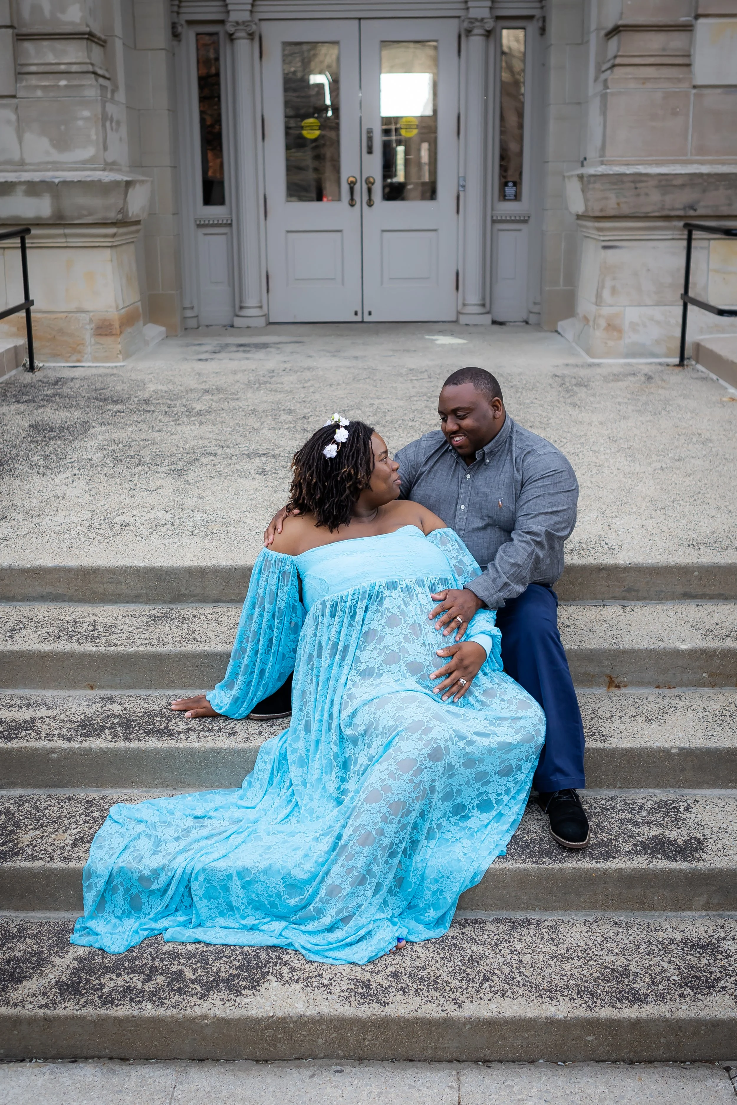 Light blue lace maternity gown with off-the-shoulder sleeves for an urban portrait session along the White River Canal in downtown Indianapolis.