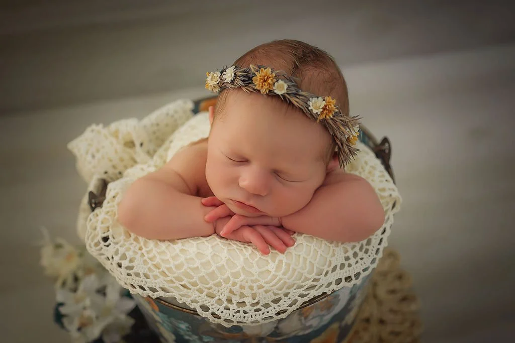 Newborn girl in floral bucket with lack edge and floral headband during her newborn photo session with Memory Lane Photography Indianapolis.