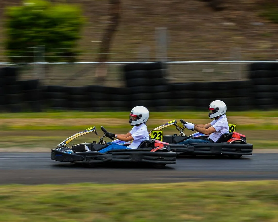 Two people driving go-karts with a blurred background