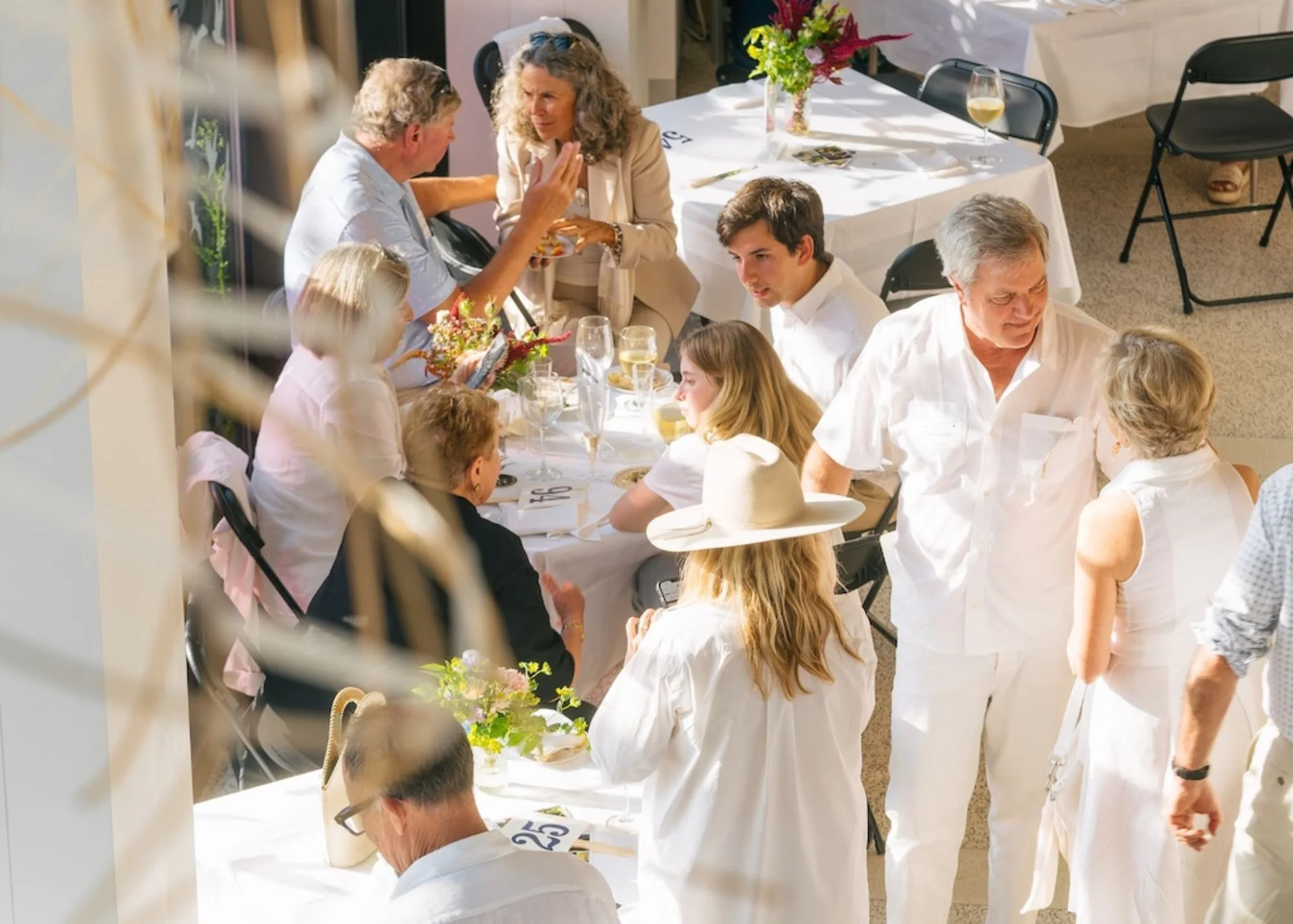 People standing and sitting around tables at 2025 auction and gala
