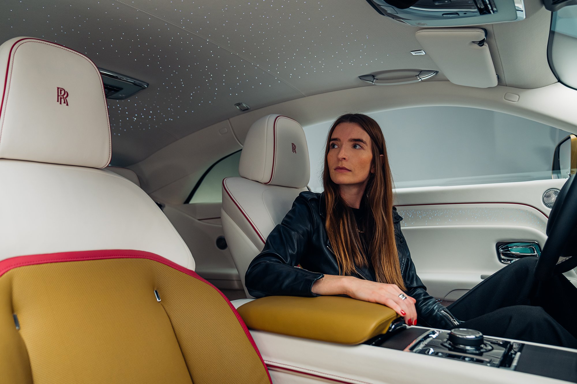 Britta Reineke, founder of ellectric sits behind the steering wheel of the first all-electric Rolls-Royce Spectre showcasing the luxurious interior design