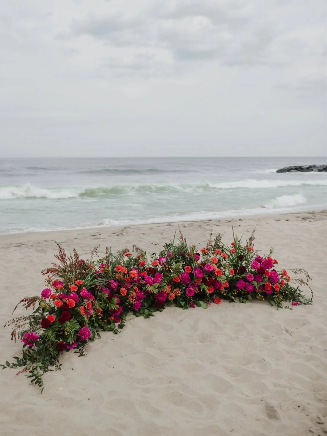Standing on the sand today, thinking back to Ava and David's ceremony in Asbury Park. We built a crescent garden installation in pinks, oranges, and coral to frame them as they said their vows, warm and sunlit and completely at home against the coast