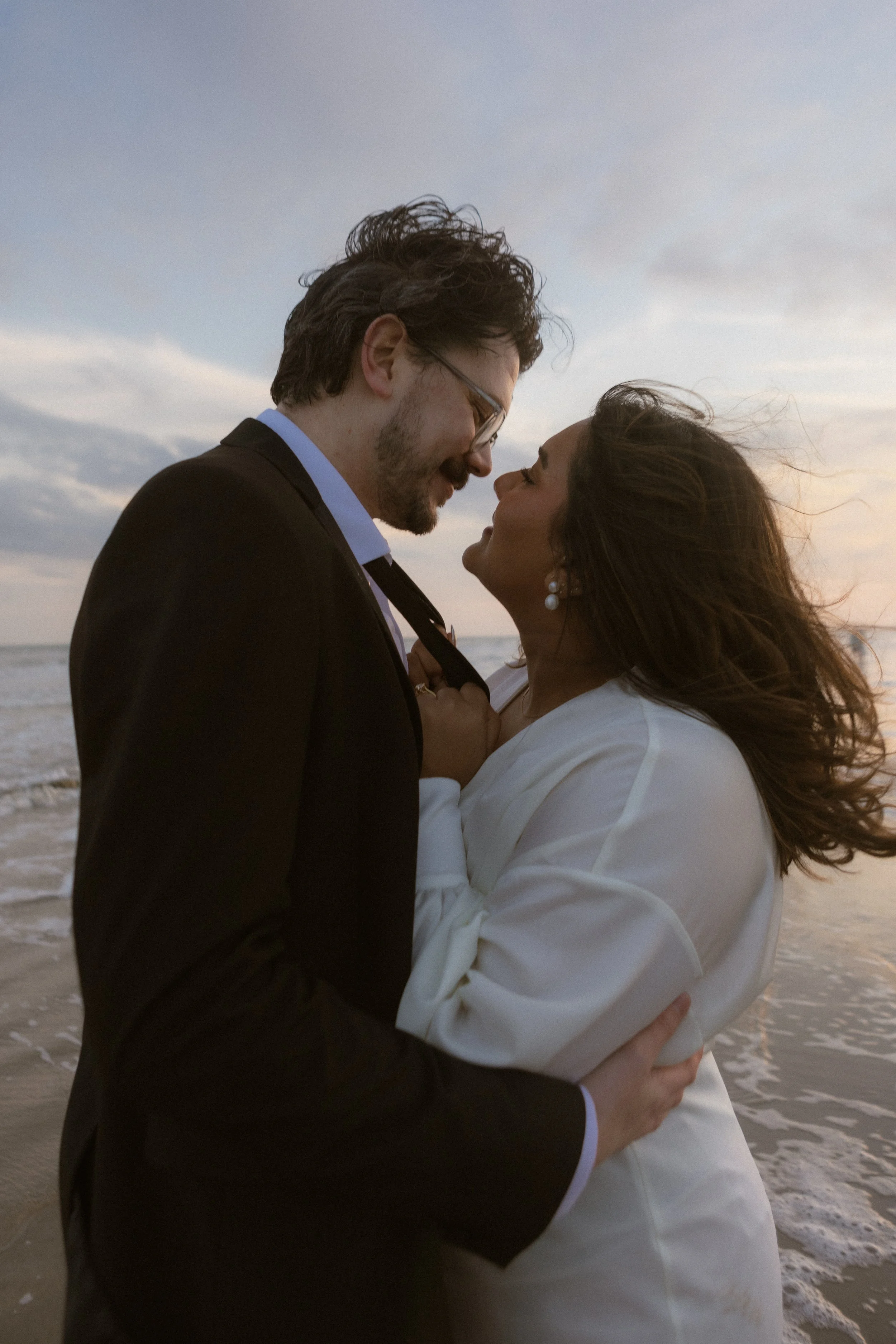 Bride and Groom lean in for a kiss while in the water at galveston