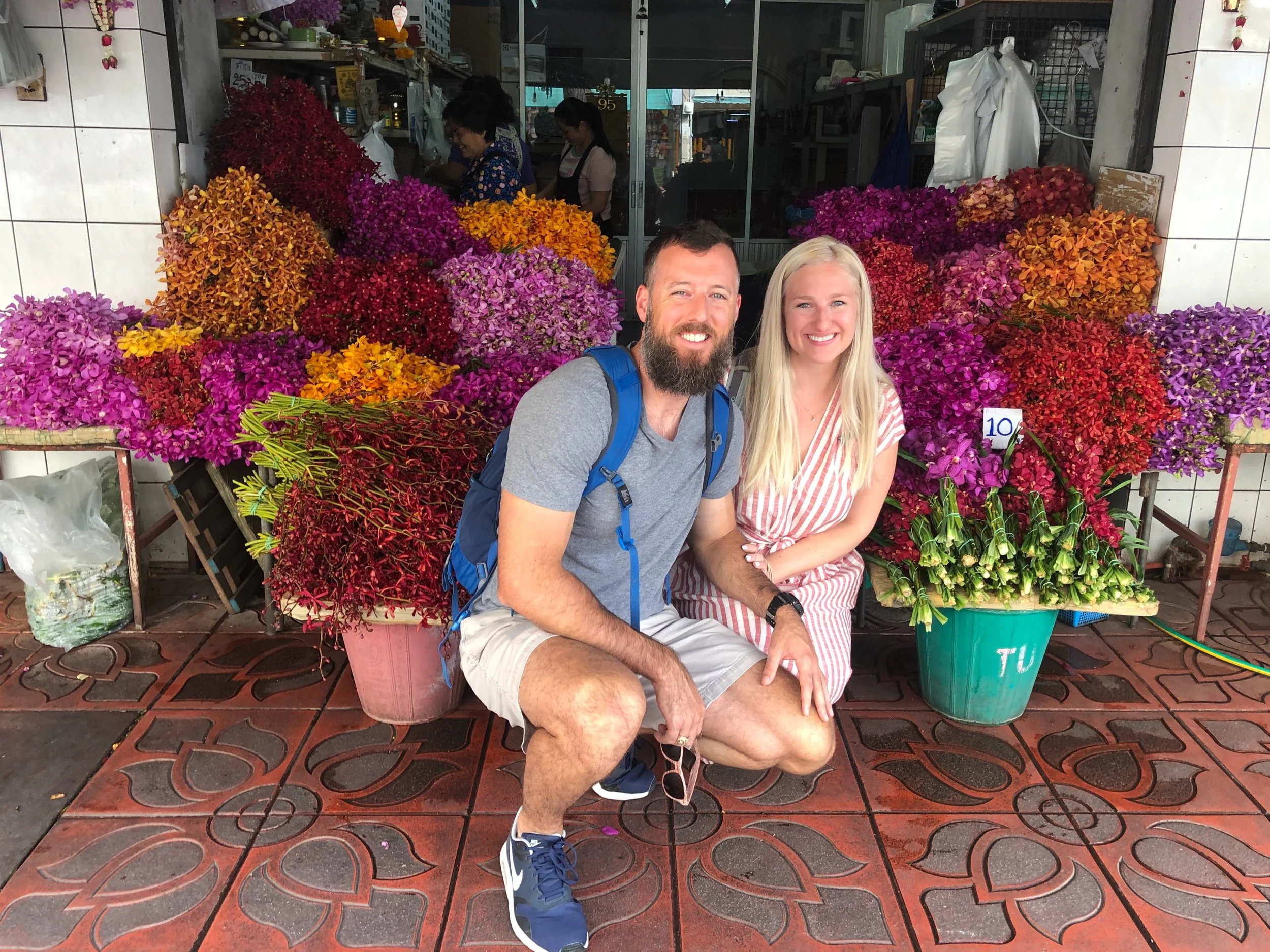 two people smiling in front of flower shop in bangkok