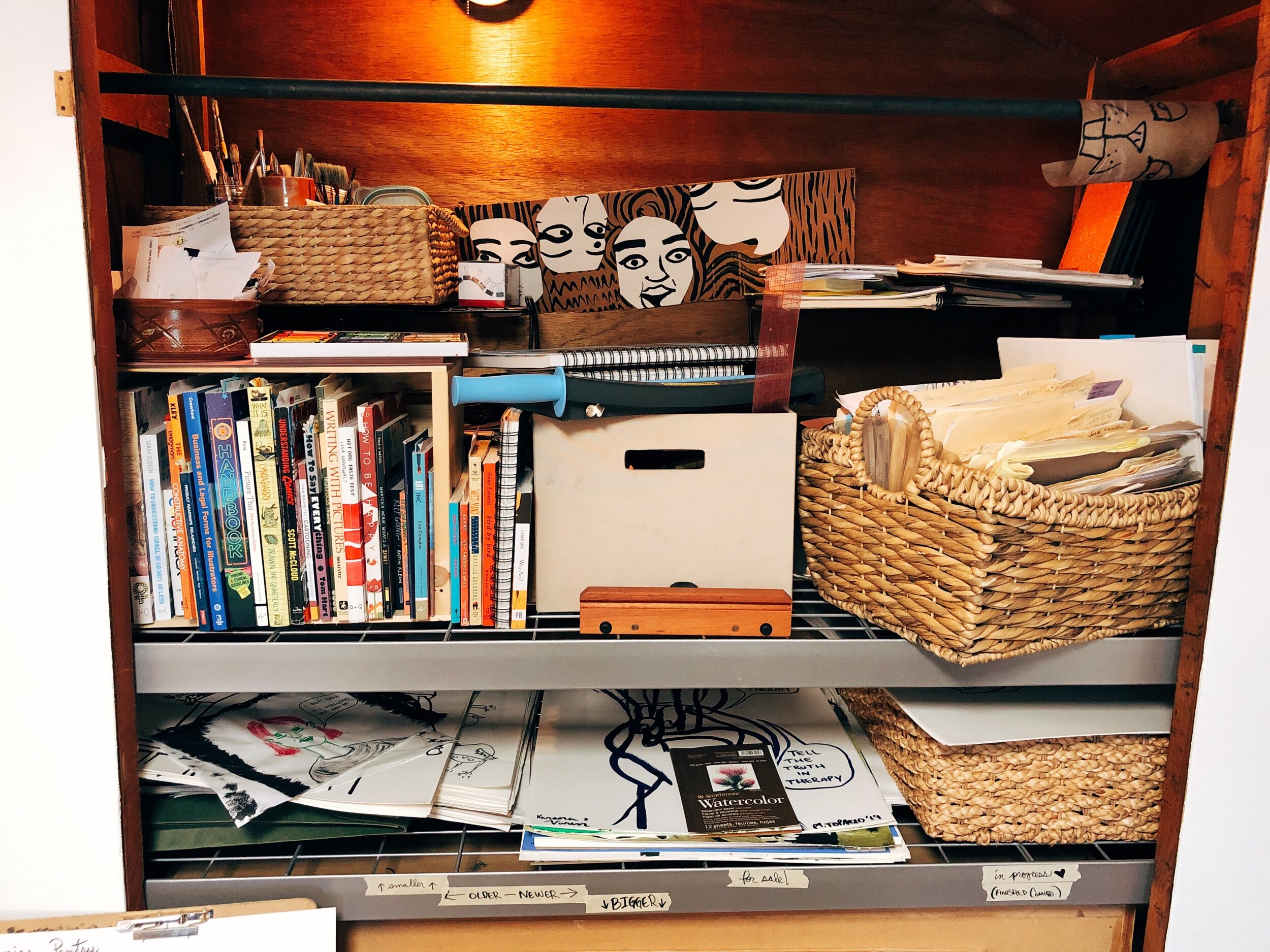 This cupboard had two doors but my nice husband removed them and now it houses stacks on stacks of organizers filled with books, paper and more art supplies.