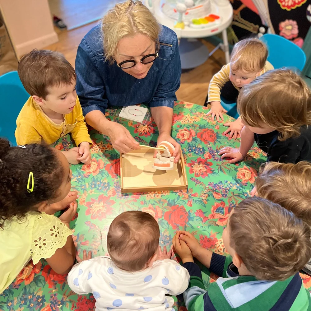 Mila, known as Baba, leading a hands-on learning activity with the children