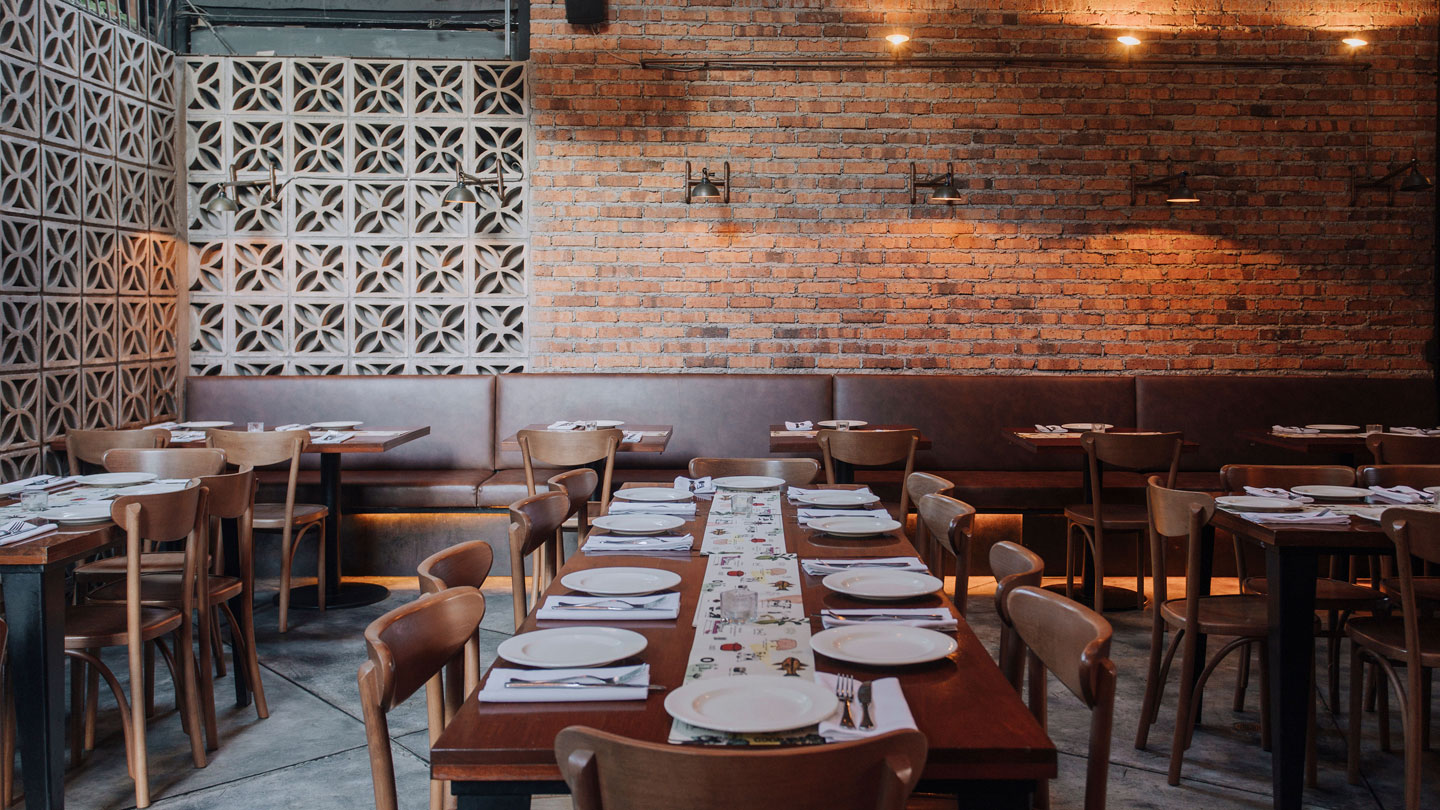 a view inside the Oci.Mde restaurant where we see its brick walls and rustic style