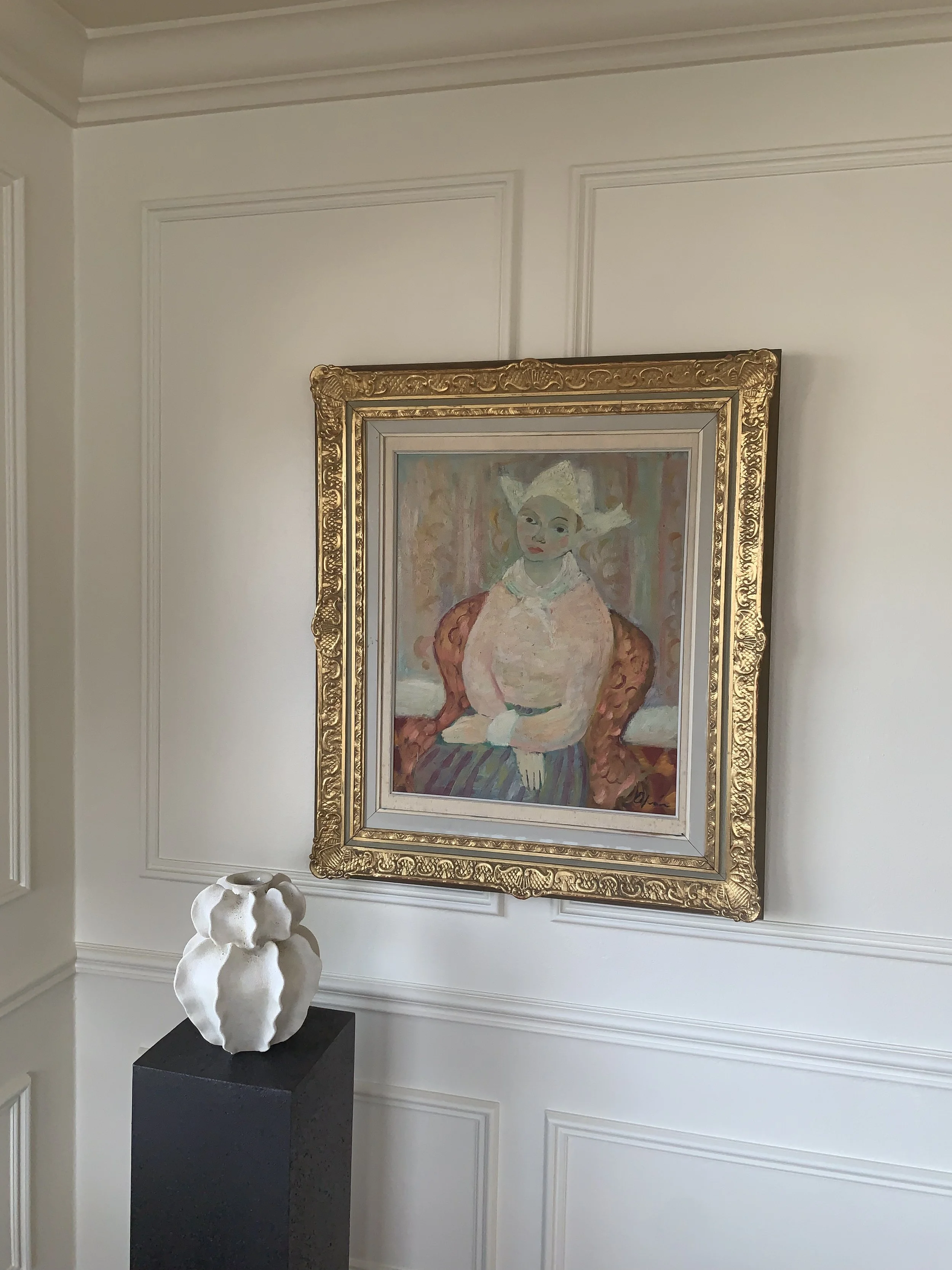 Detail of ‘Young Woman in Hat’ (ca. 1940s) by Eric Elfven, a framed oil painting showing the painting hanging on a wall in a room.