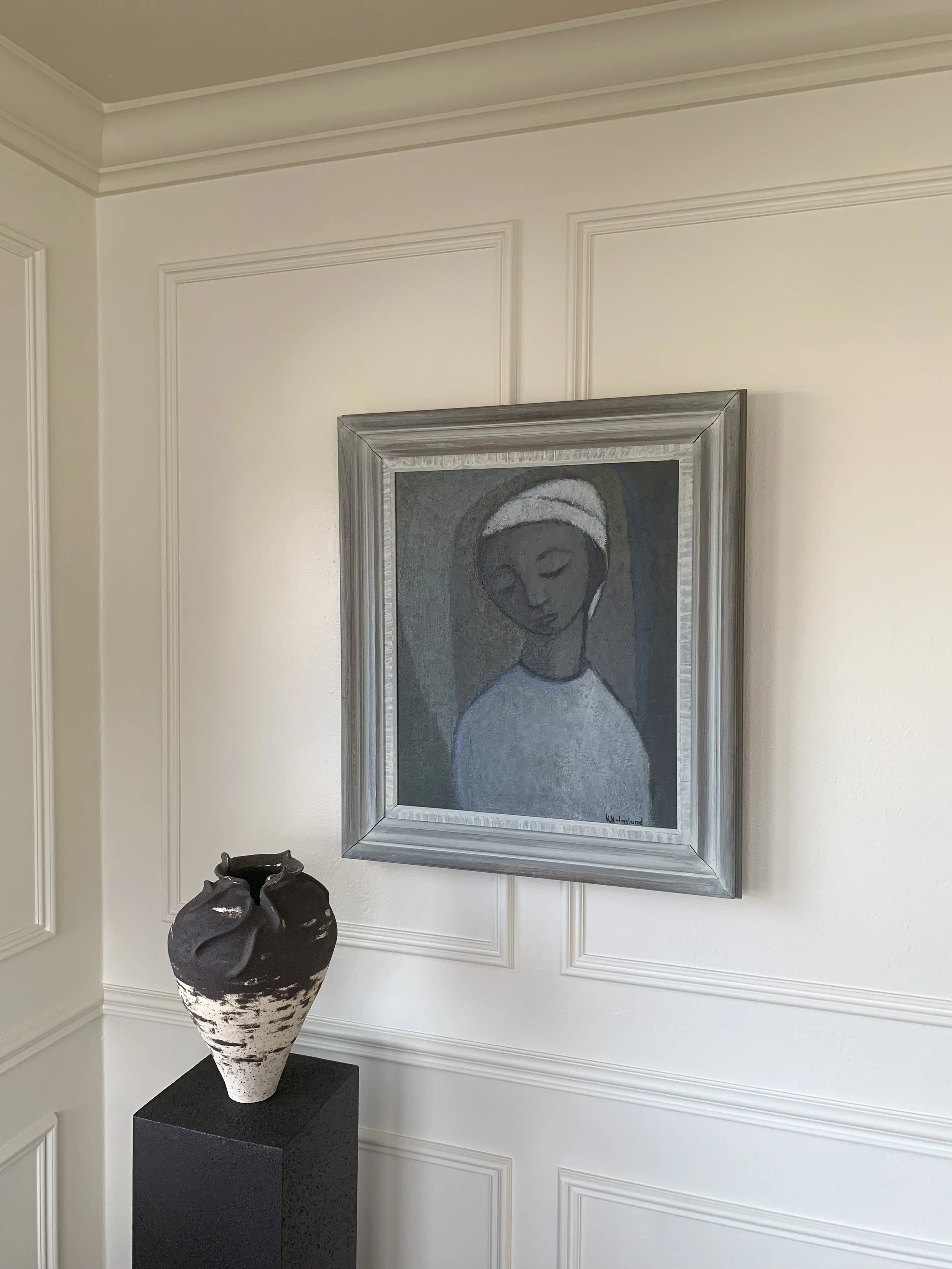 Detail of ‘Portrait of a Woman in White’ (ca. 1960s), a framed minimalist oil painting shown hung on a wall in a room.