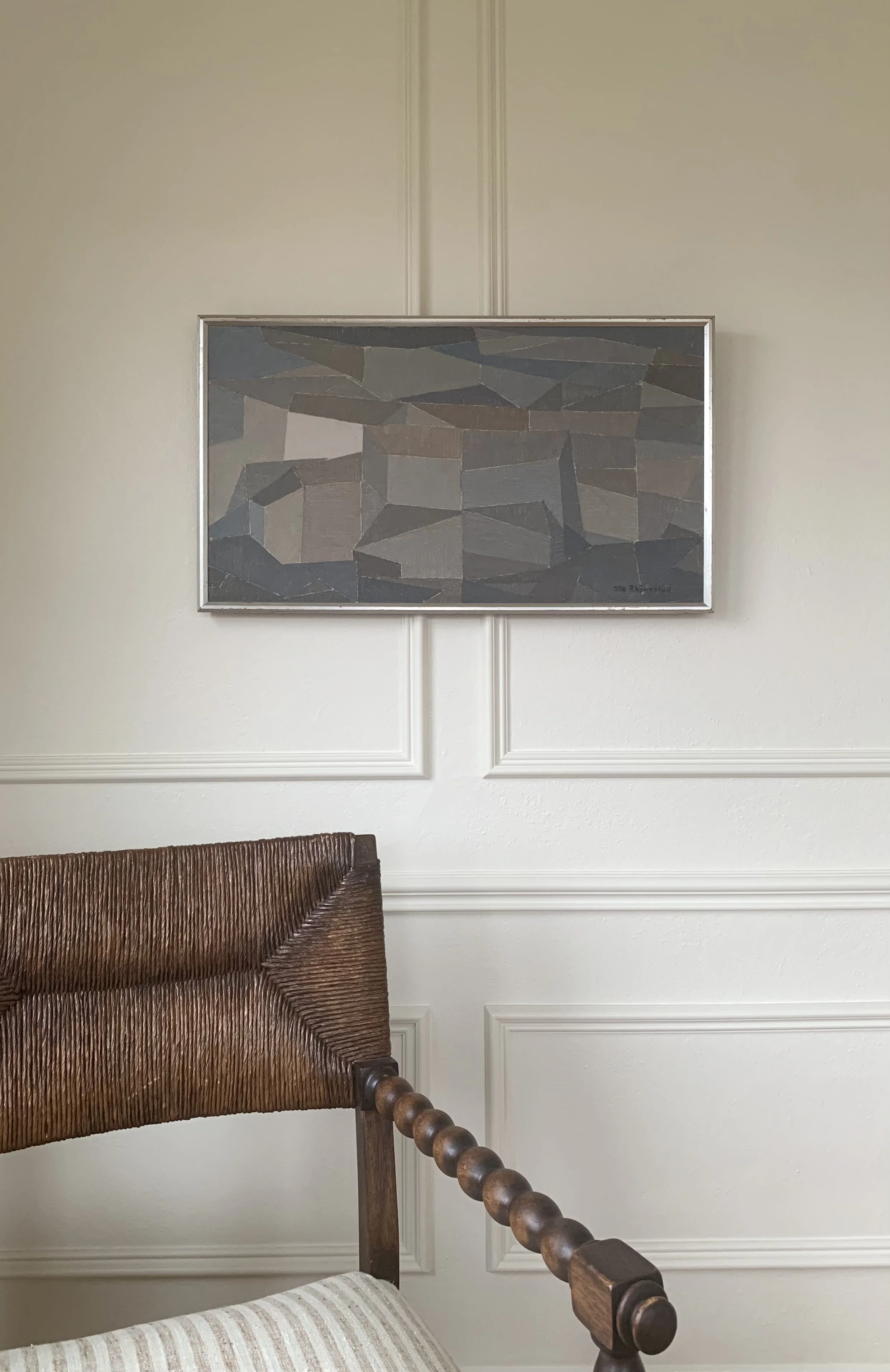 Detail of ‘Muted Cityscape’ (ca. 1950s) by Olle Rhonnstad, a framed Modernist oil painting showing the painting hanging on a wall in a room.