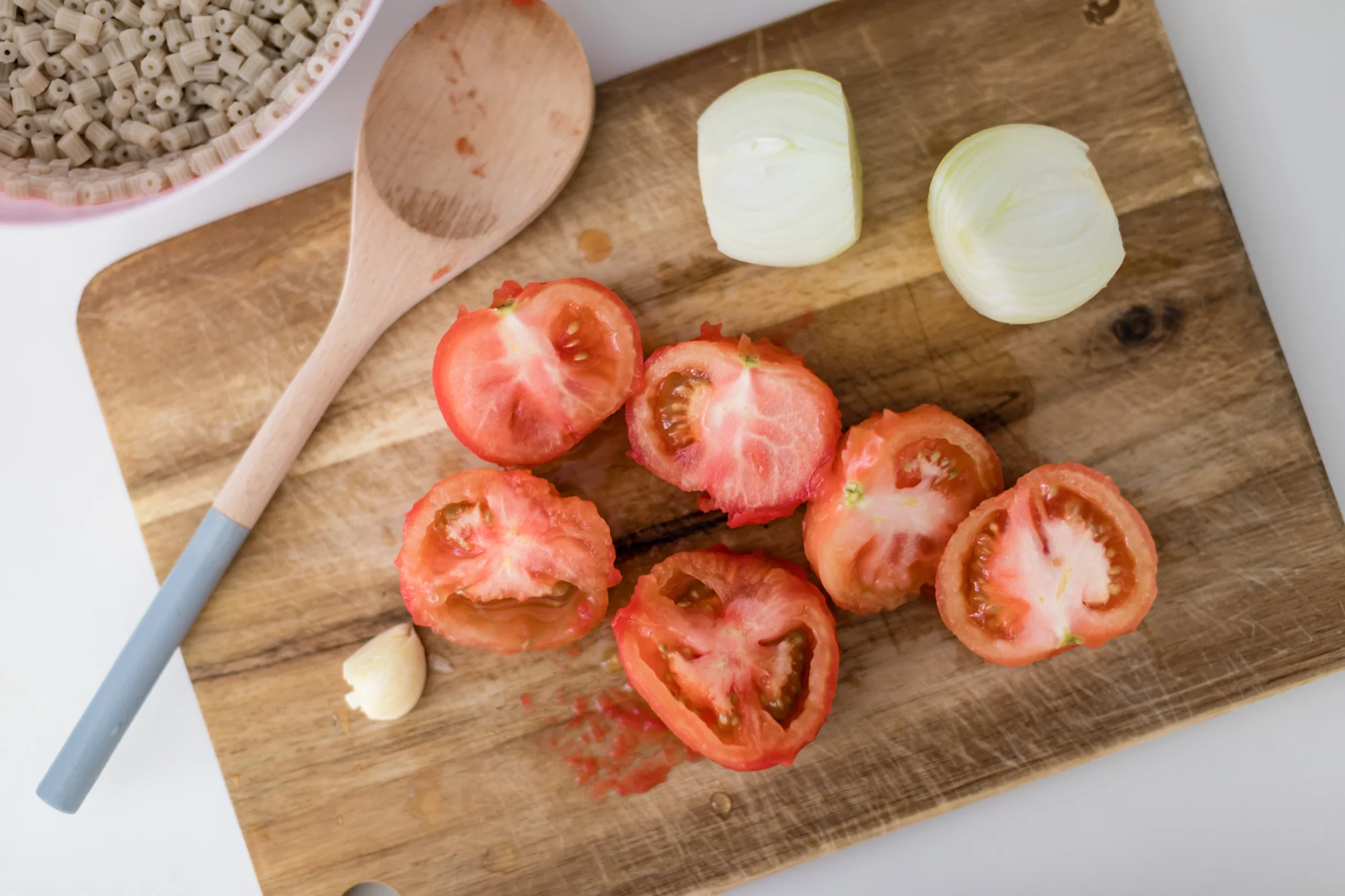 Blanch the tomatoes in boiling water for a minute and remove skin. Cook through pasta in boiling water and drain.