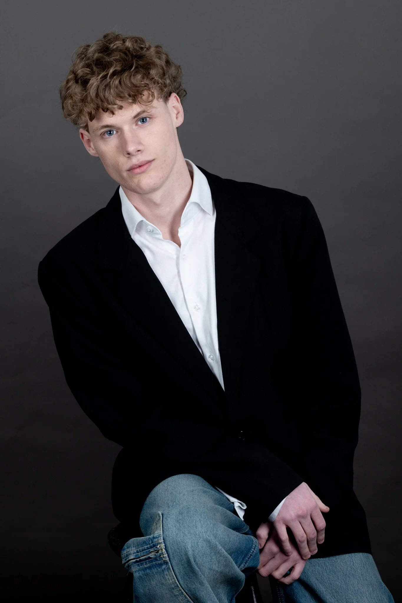 Male fashion model in blazer and jeans posing confidently for professional modelling portfolio with entrepreneurial mindset