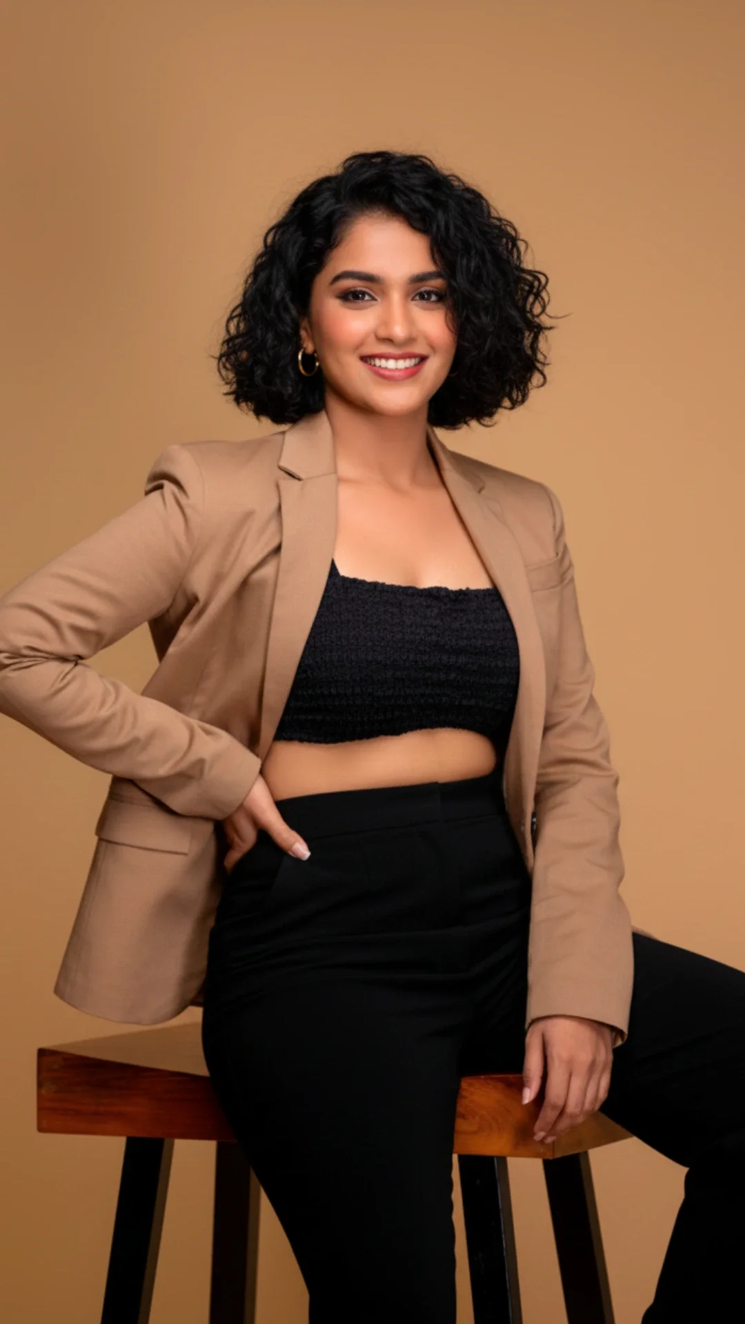 Commercial model posing confidently in a studio wearing smart casual fashion, showcasing versatility and approachability for commercial modelling campaigns