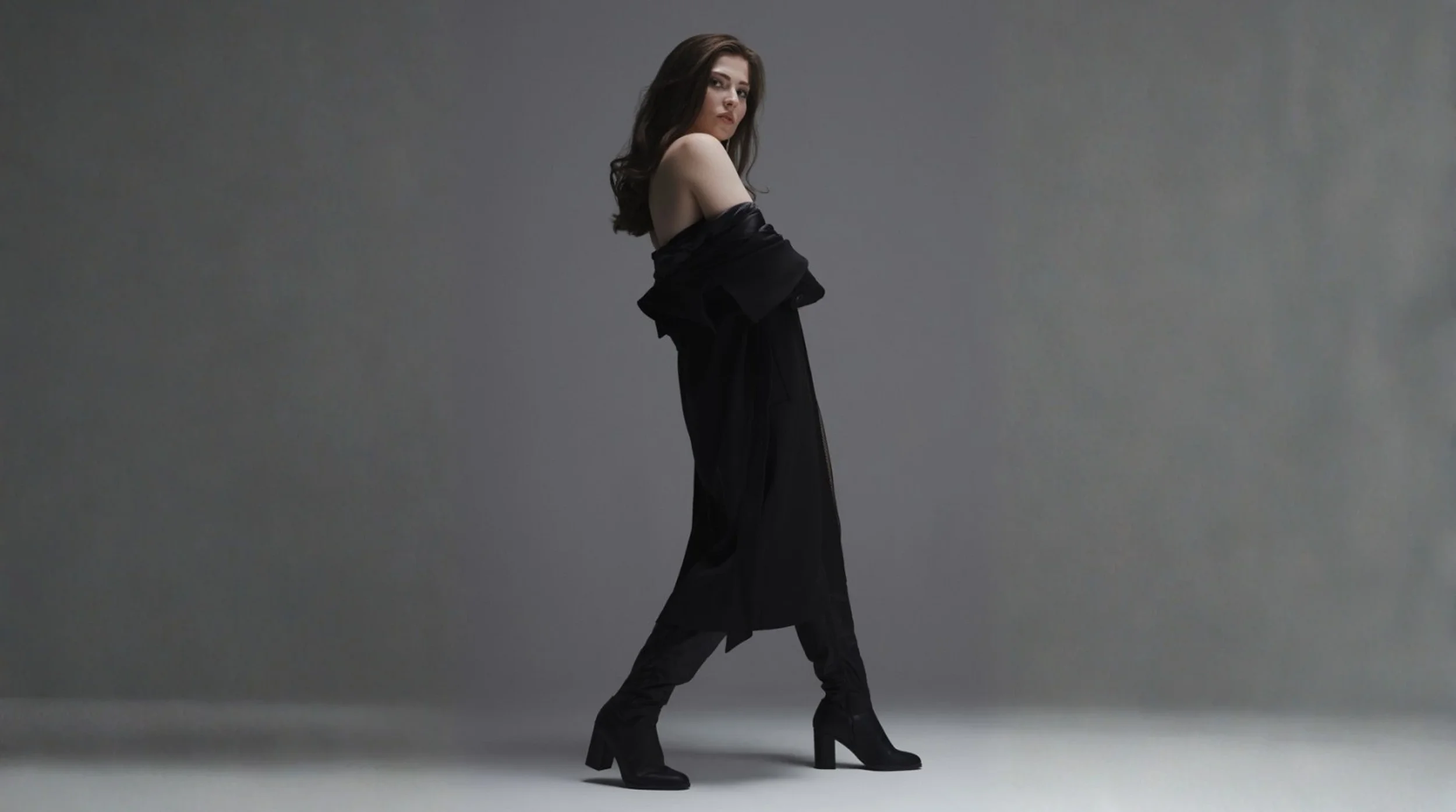 Model demonstrating professional runway movement and posing skills during a studio photoshoot