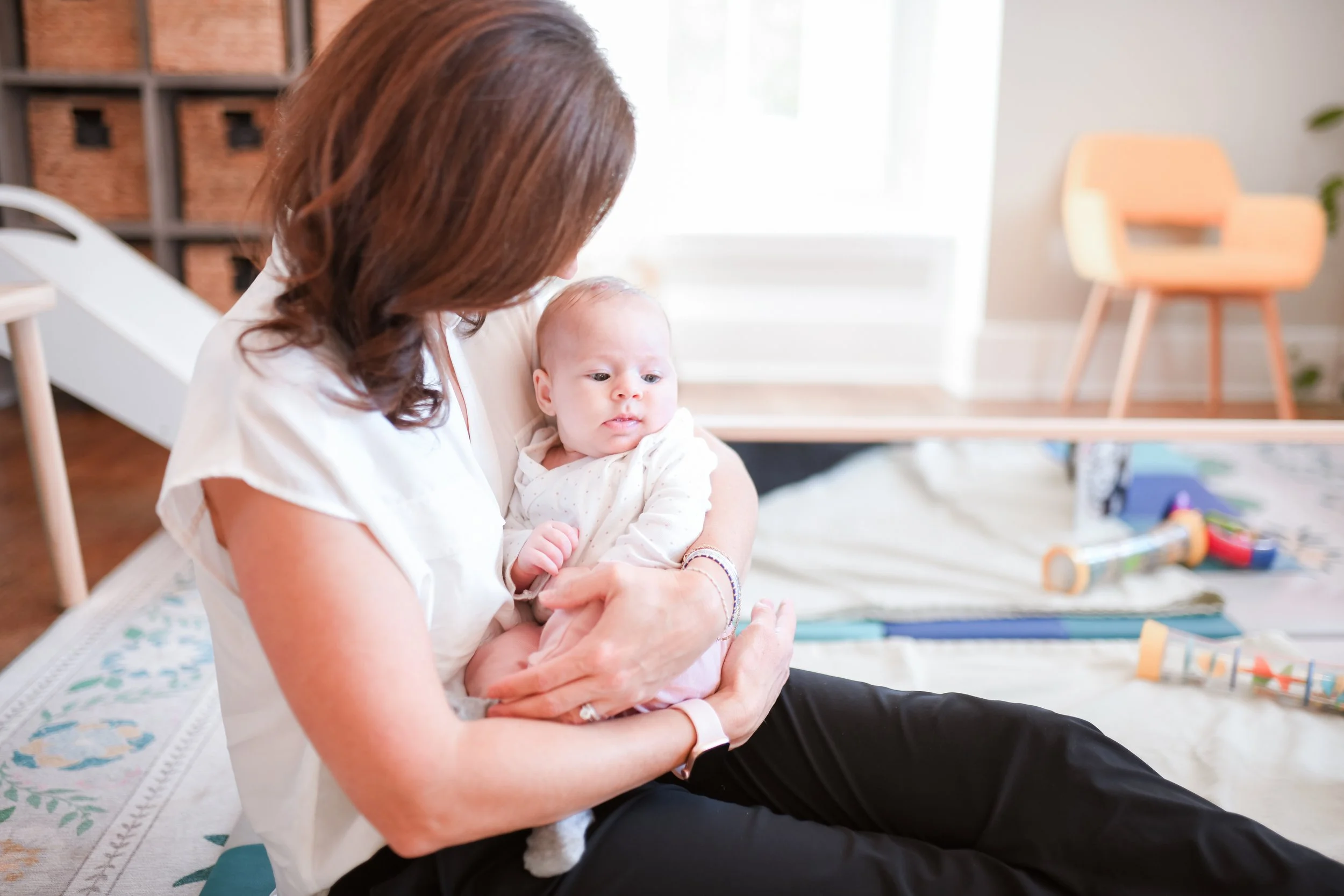 Dr. Sarah Oleksak cradling a baby in the infant treatment room at Bloom