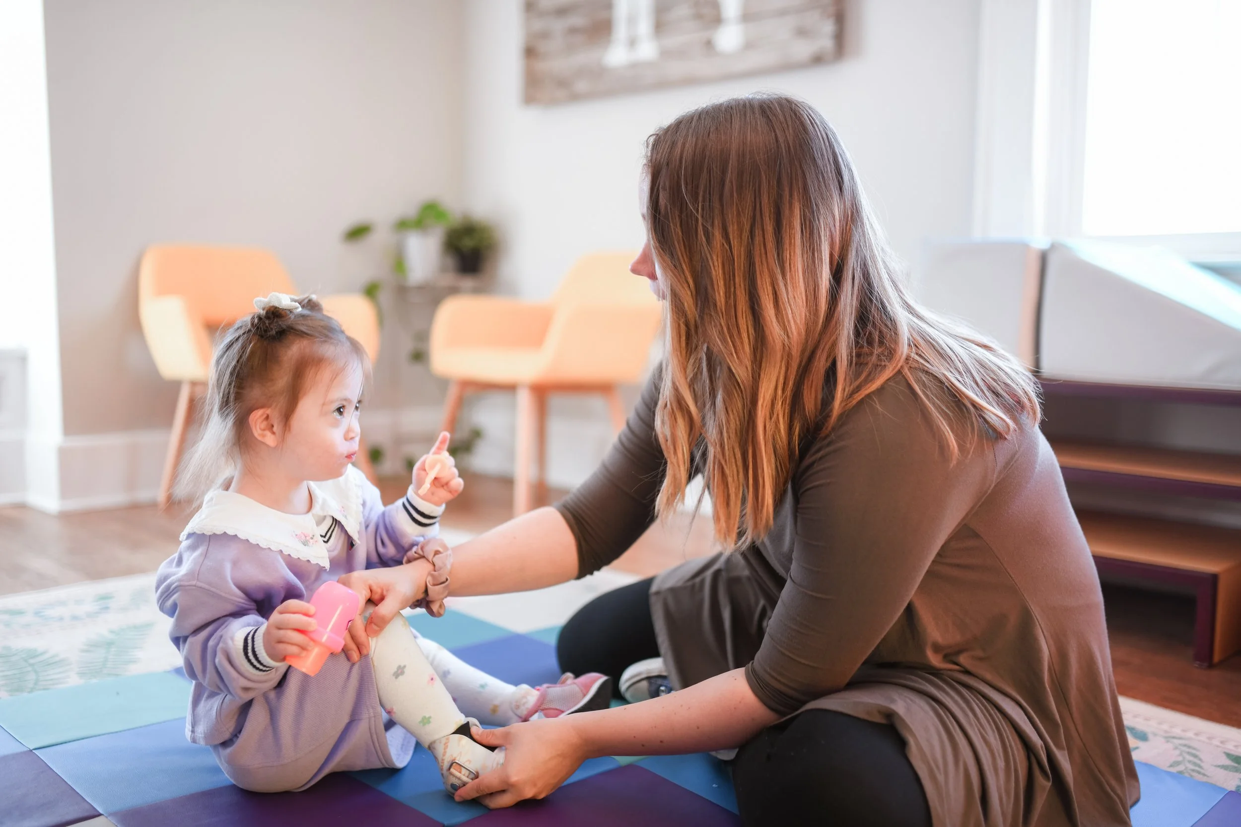A child pointing to Marisa in the pediatric treatment room at Bloom