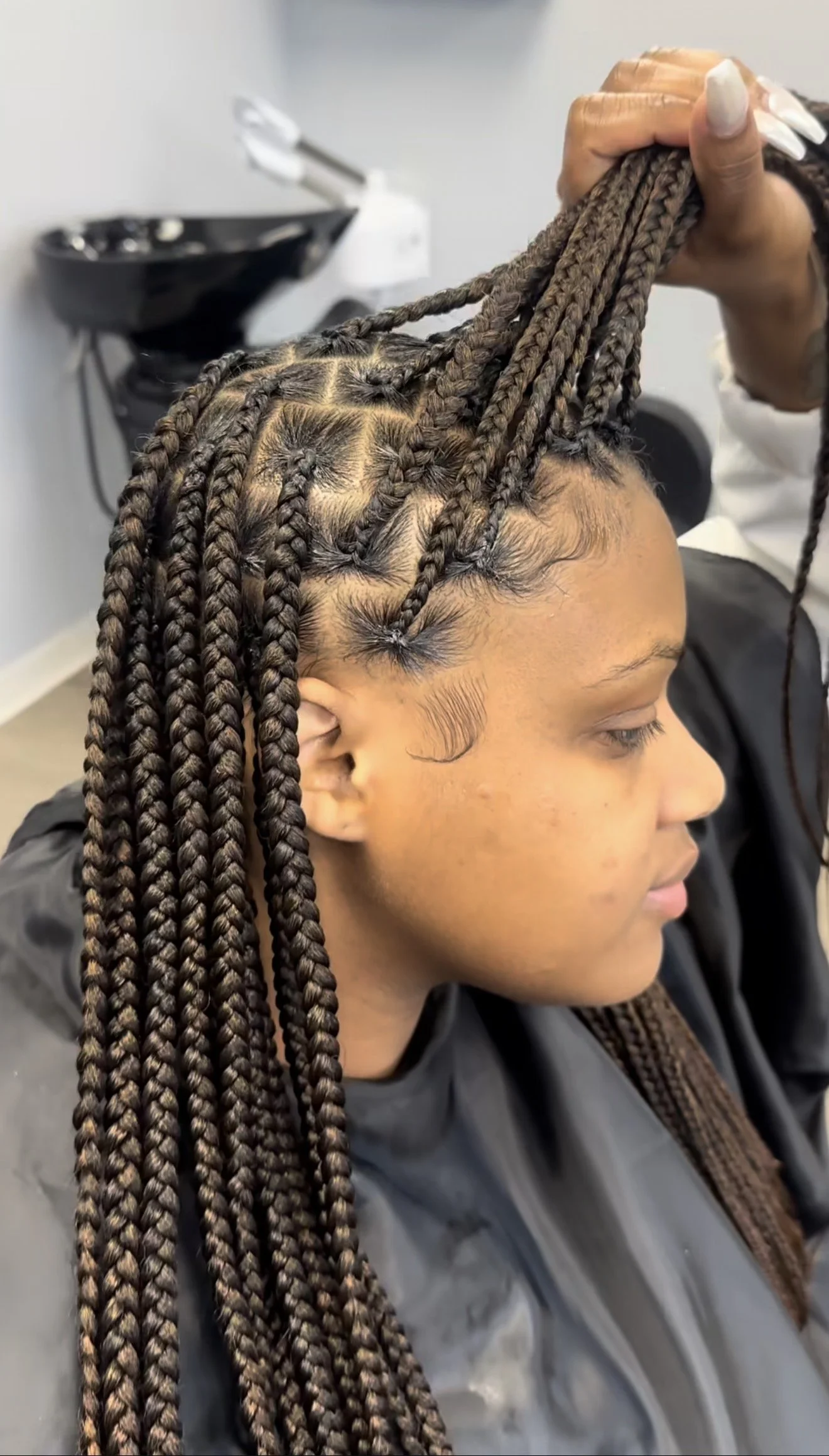 Close-up of knotless braids installed by Beautiful Luxe School of Cosmetology student Charniece, showcasing clean parts, tension control, and professional braiding technique.