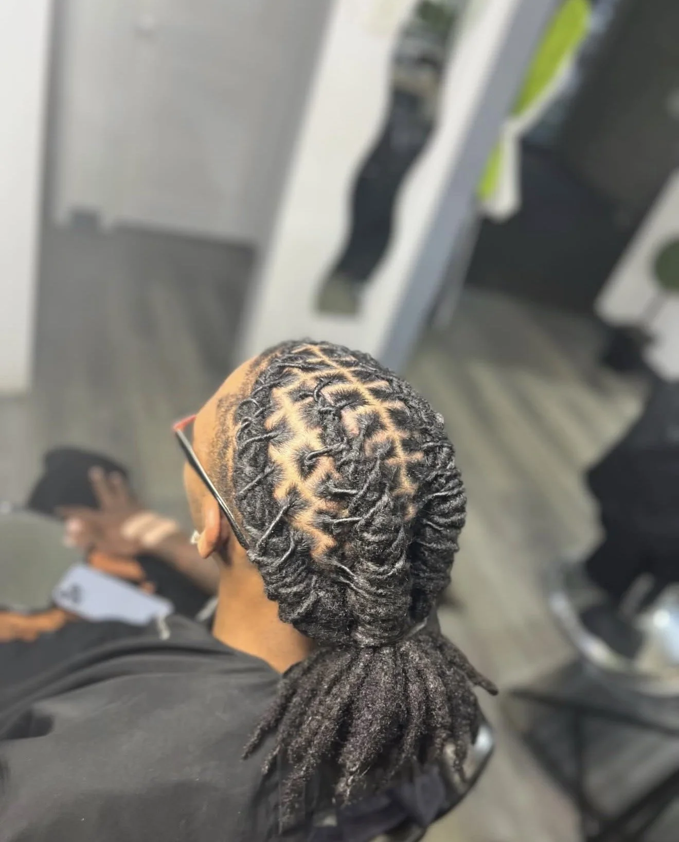 Close up overhead view of a cosmetology student creating a barrel twist style on a client