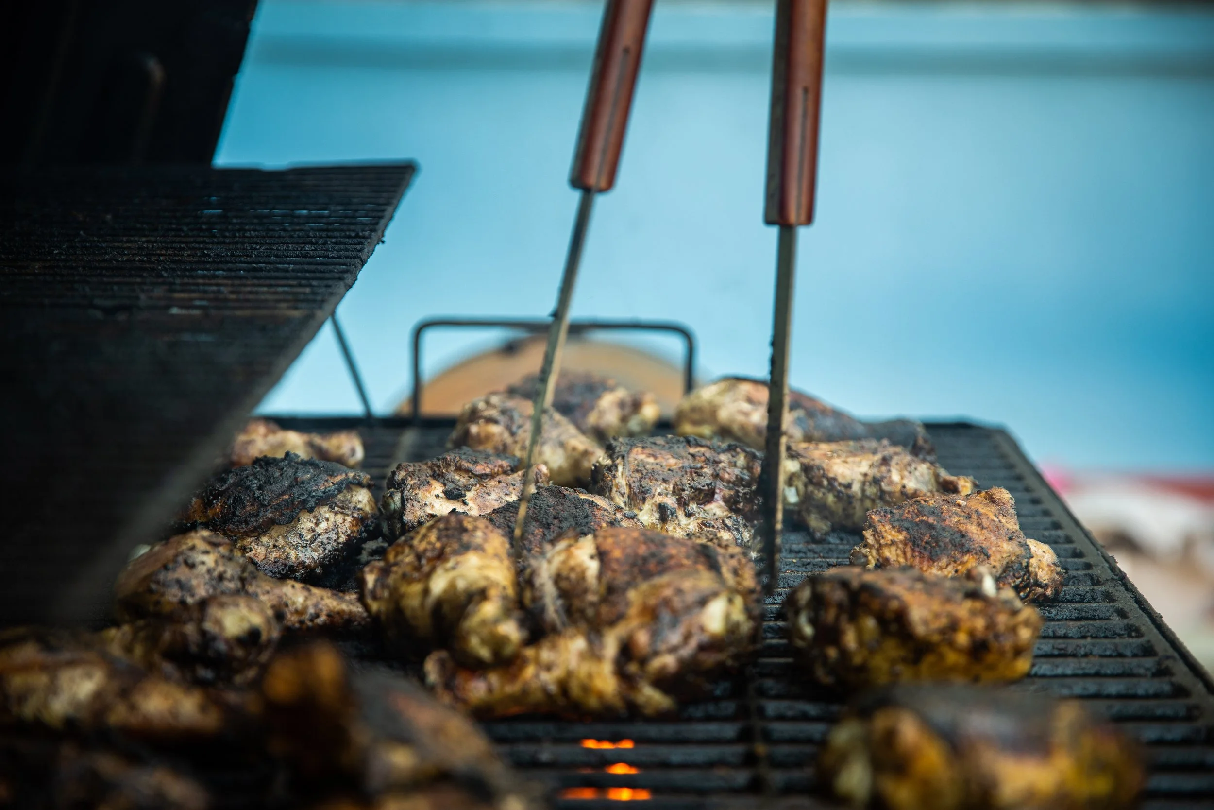 Carne asada cocinándose en una parrilla con brasas.