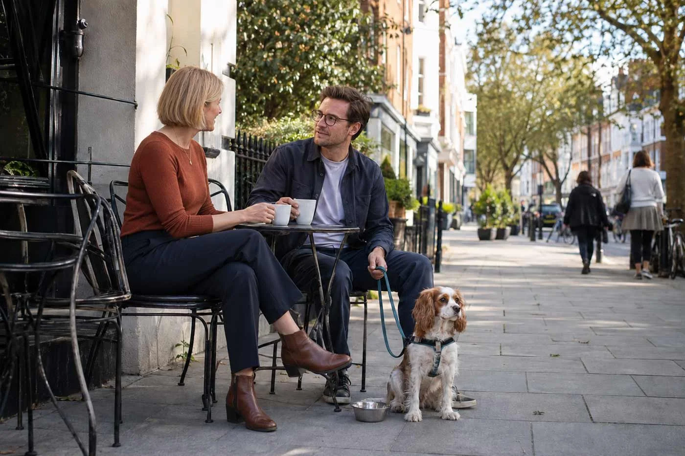 Small dog sitting beside its owners at an outdoor London café