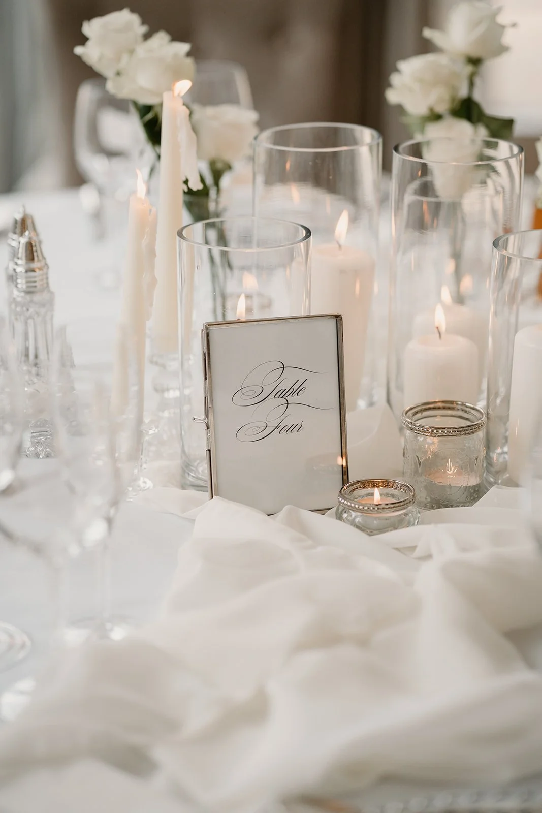 Wedding centrepiece with candles and flowers and table number styling