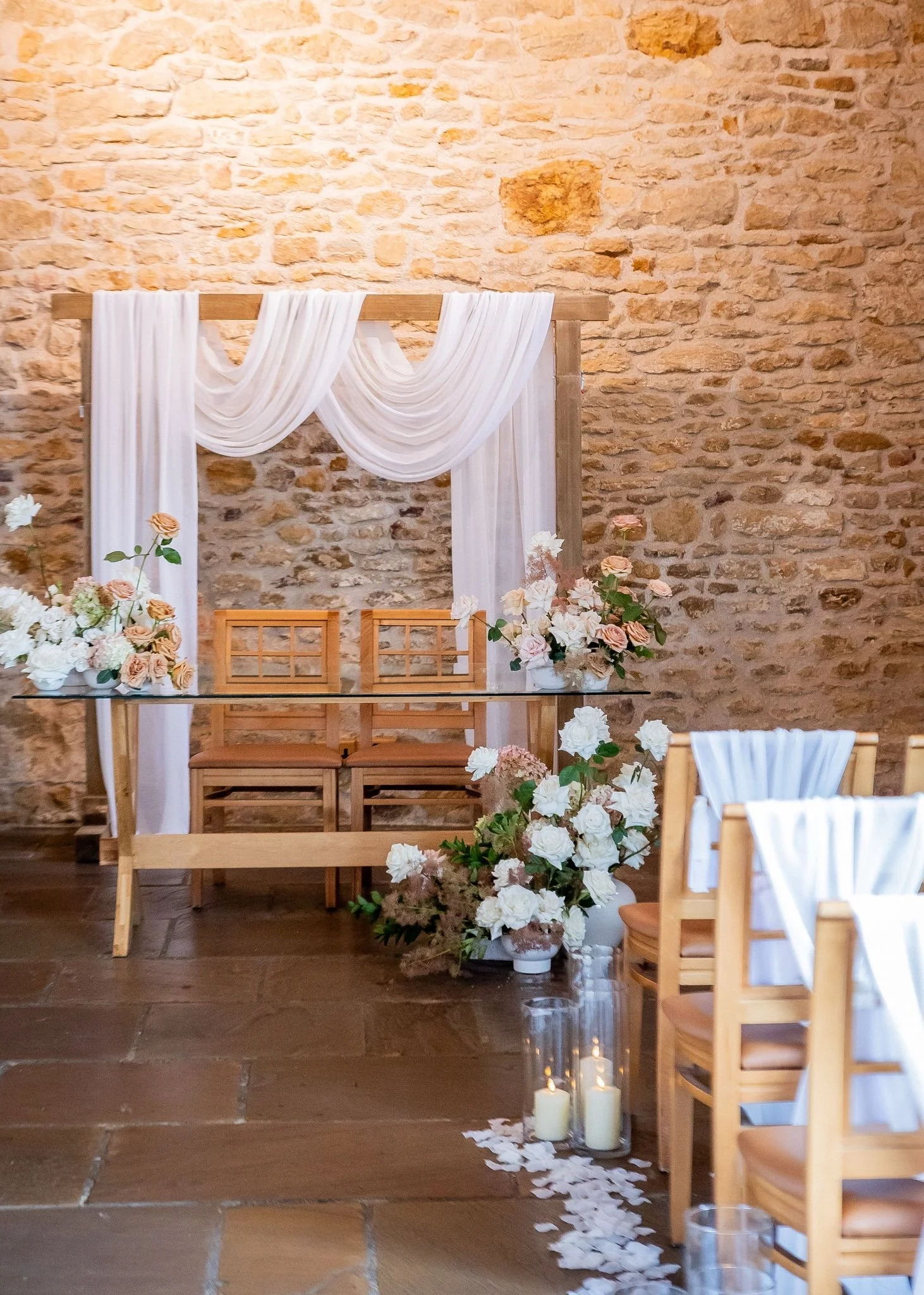 Wedding Backdrop in ceremony room with draping chair, drapes and candles down the aisle