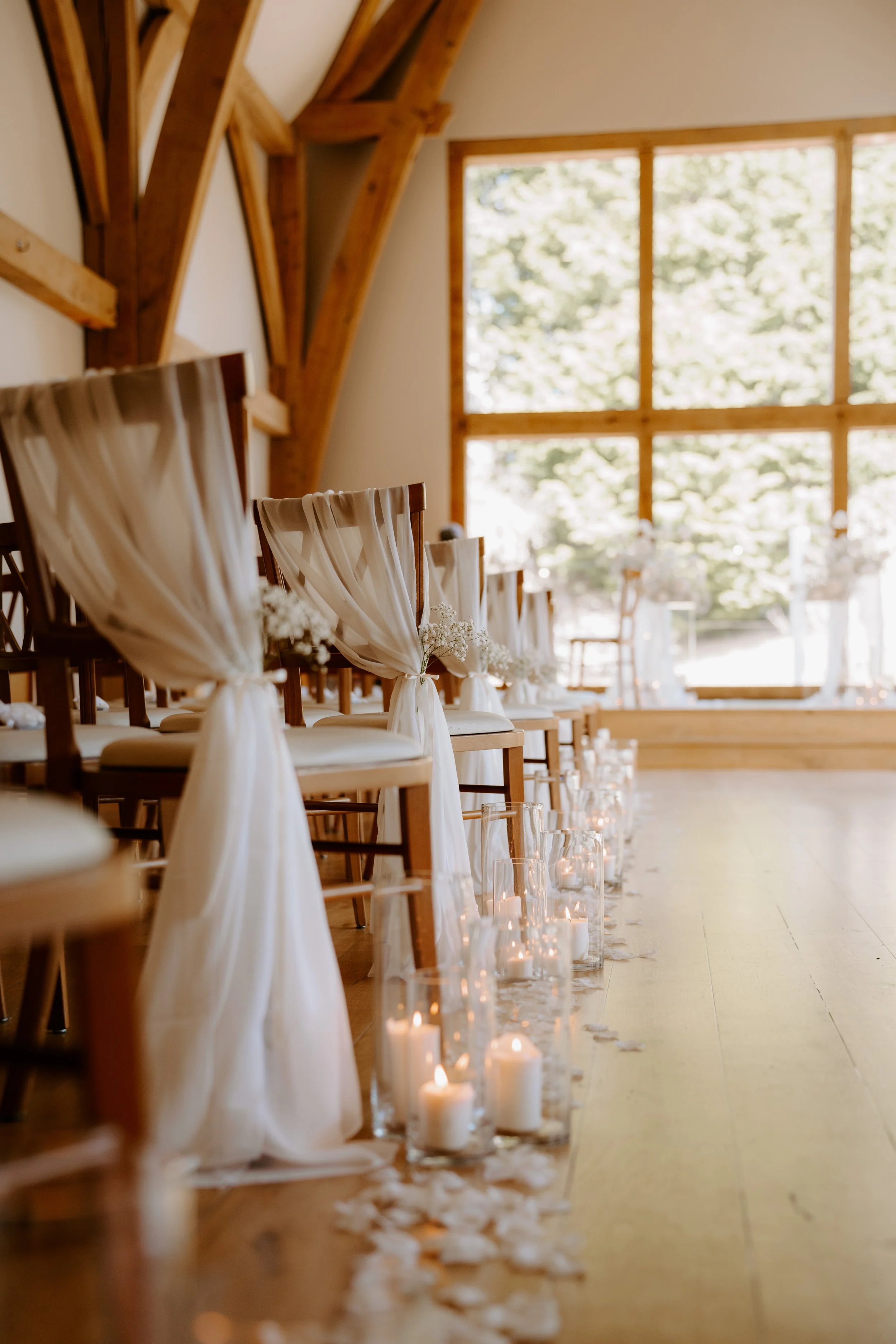 Ceremony aisle decor with chair, drapes, candles, and petals in Shropshire