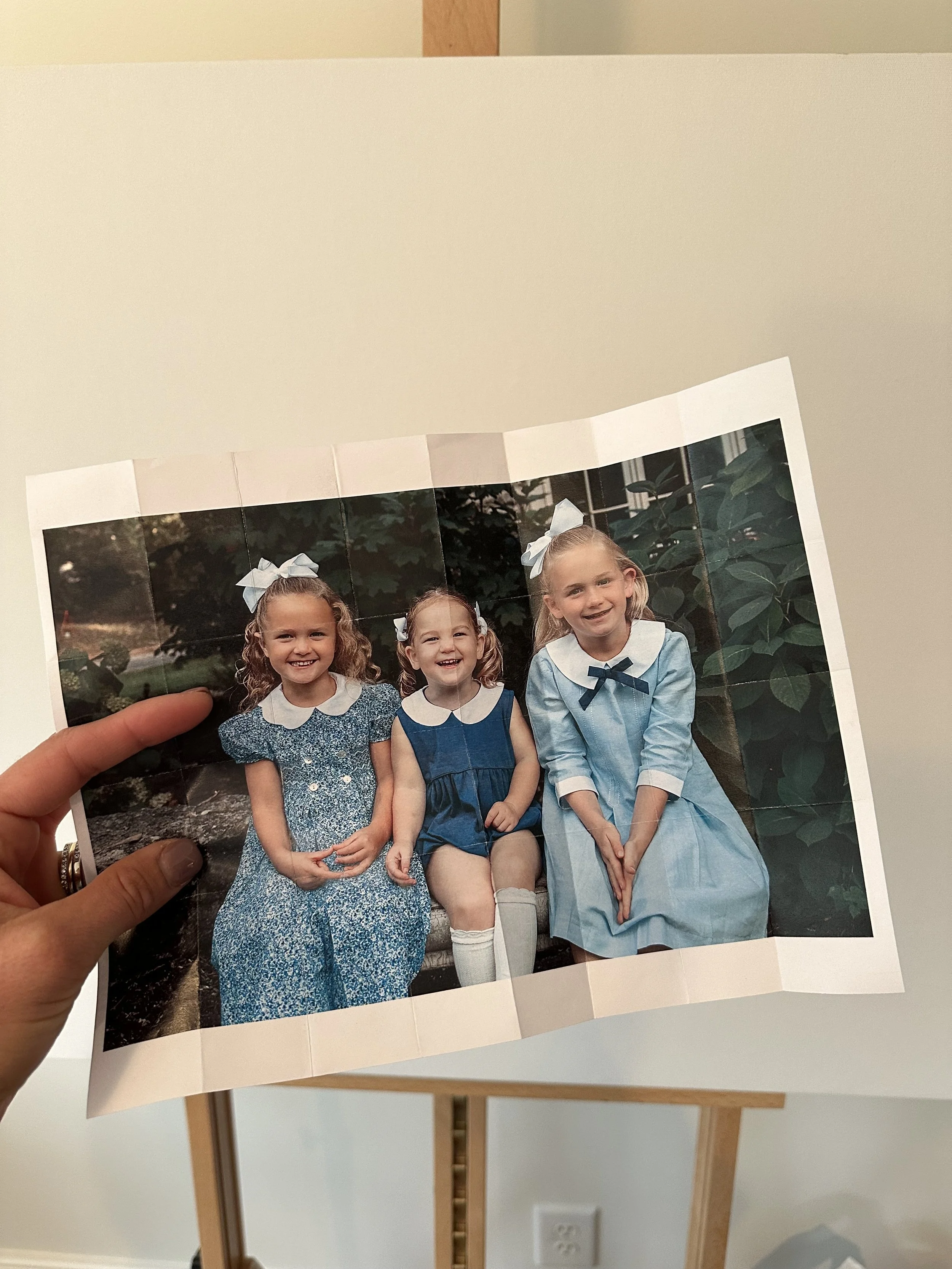 Holding the printed photograph in hand, the blank canvas waits in the background — the very beginning of a journey to bring this moment to life in oil.