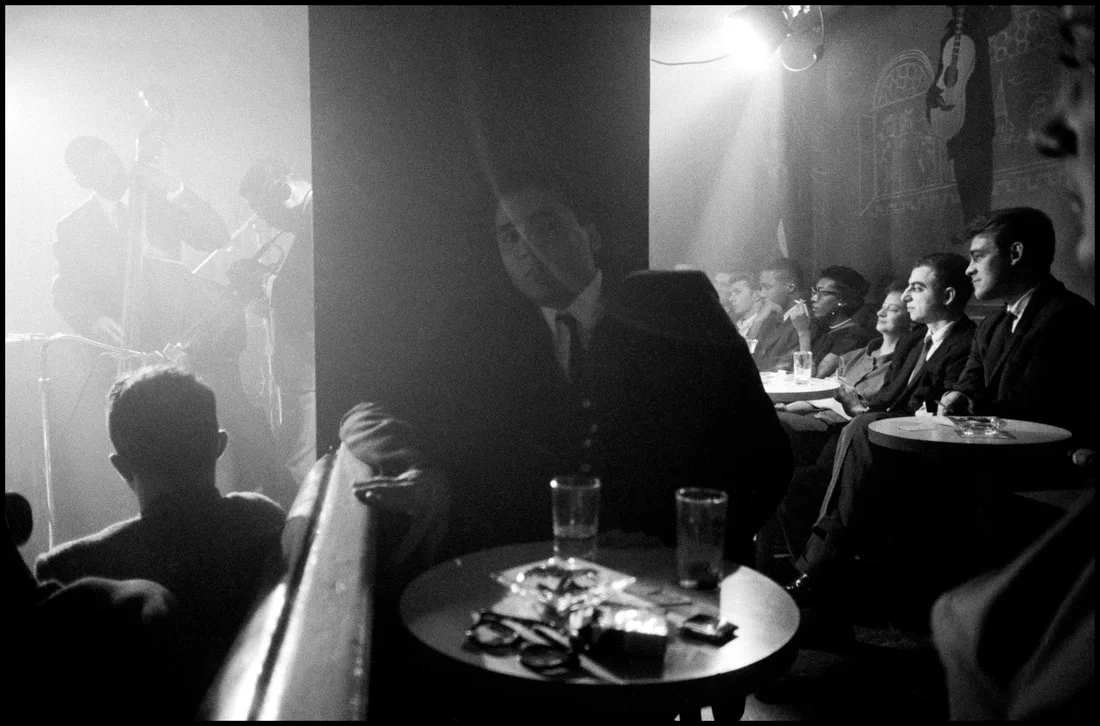 Patrons at the Village Vanguard in 1958, with Miles Davis on stage at the far left (Photo: Dennis Stock/Magnum Photos)