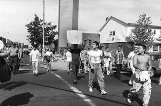 Bensonhurst residents shout racial slurs and taunt marchers as they walk toward the 62nd Precinct to protest the murder