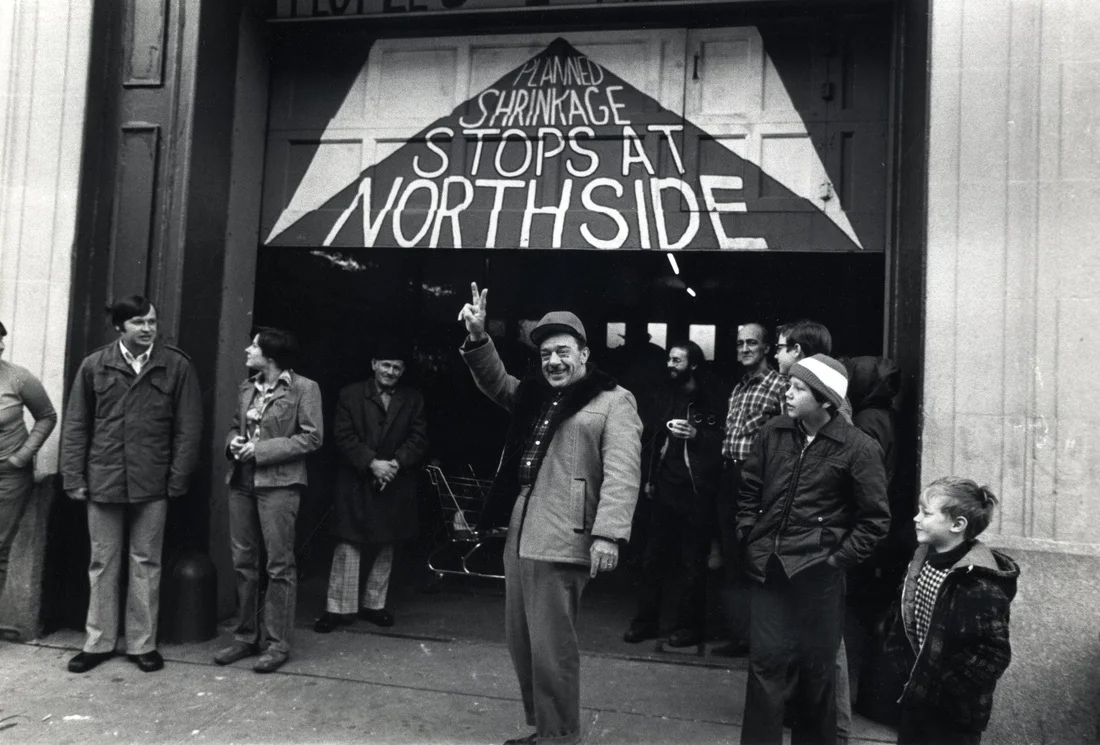 In 1975-76, as New York City's fiscal crisis worsened, the head of of city housing development, Roger Starr, announced a controversial policy of "planned shrinkage": the withdrawal of police and fire stations and the closure of schools, hospitals, and subway stations in poor and non-white areas of the city. Firehouse 212 was slated for closure by the city; beginning on Thanksgiving Day, 1975, Northside residents occupied it for 18 months in a civil disobedience campaign aimed at stopping the cuts. They painted this mural on the Firehouse door. Photograph by, and courtesy of, Janie Eisenberg.