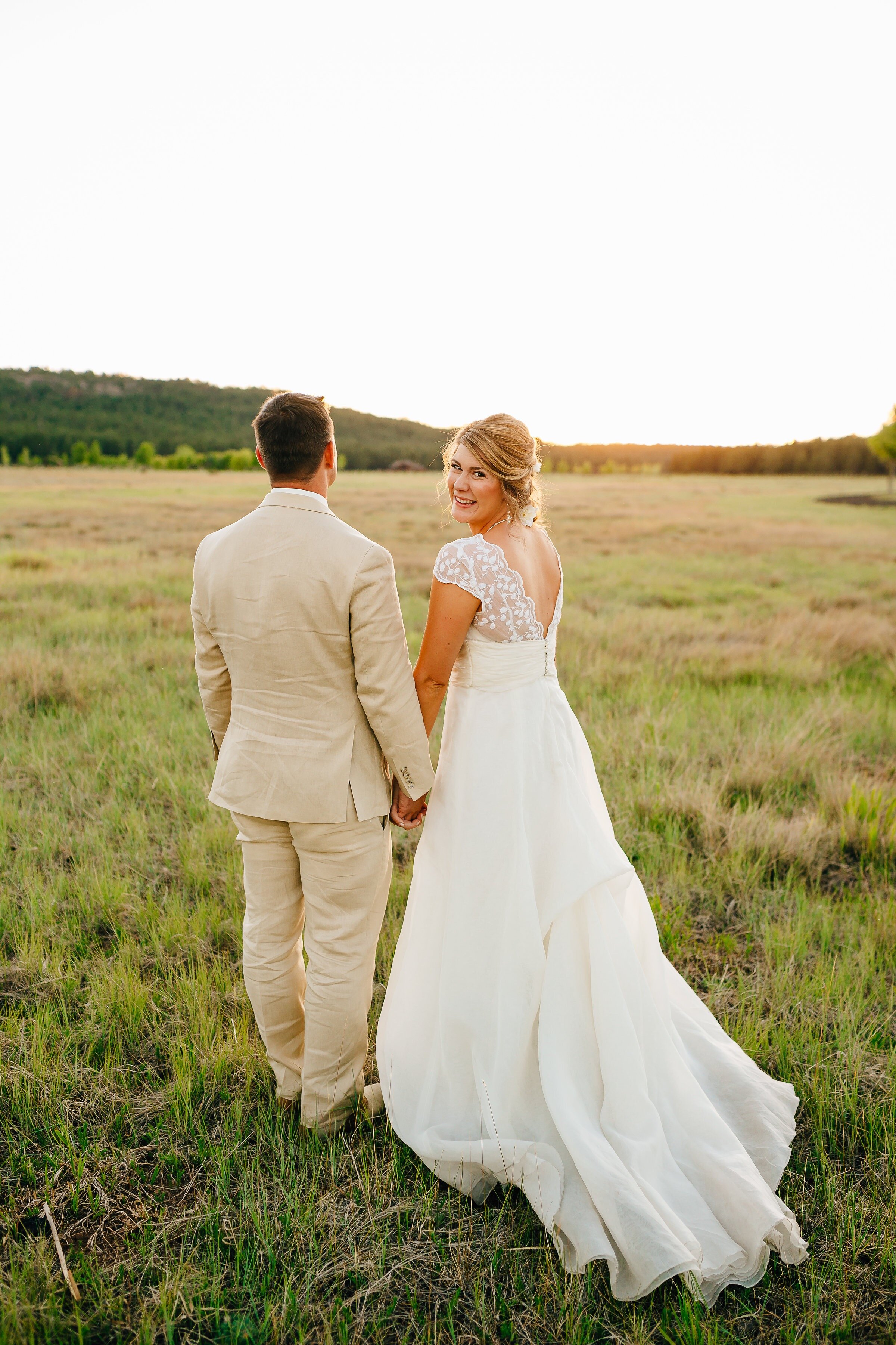 Bride wearing open back lace wedding dress with tulle skirt and groom in the farm wedding with sunset.jpg