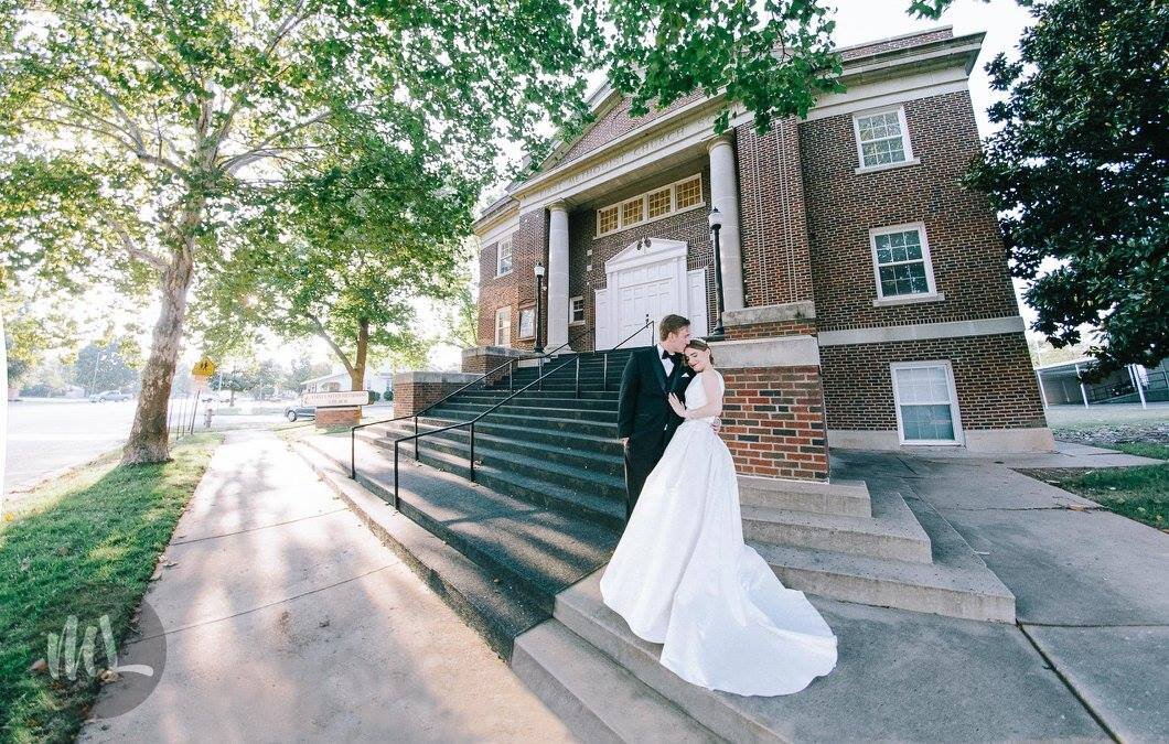 Bride and groom in front of the chapel wearing bespoke couture wedding gown.jpg