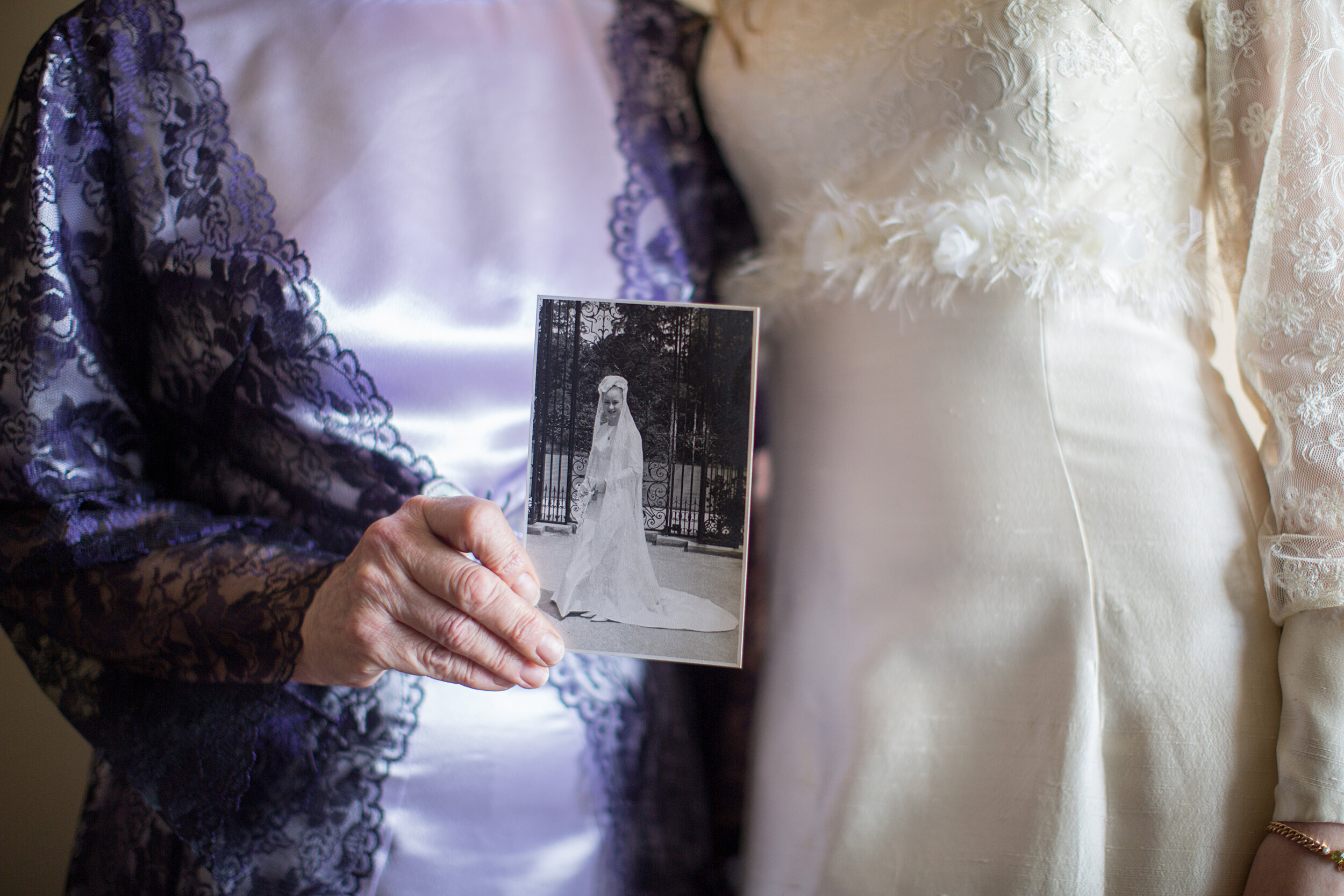 Grandmother showing her vintage picture with upgraded wedding dress of granddaughter.jpg