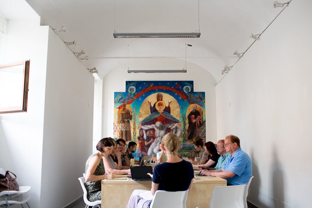  The participants in the Lilly Fellows Program Summer Seminar for College Teachers gathered in the sala for discussion, under the eye of the Madonna della Misericordia, a painting jointly created by Bruce Herman’s painting study class and Matthew Mil