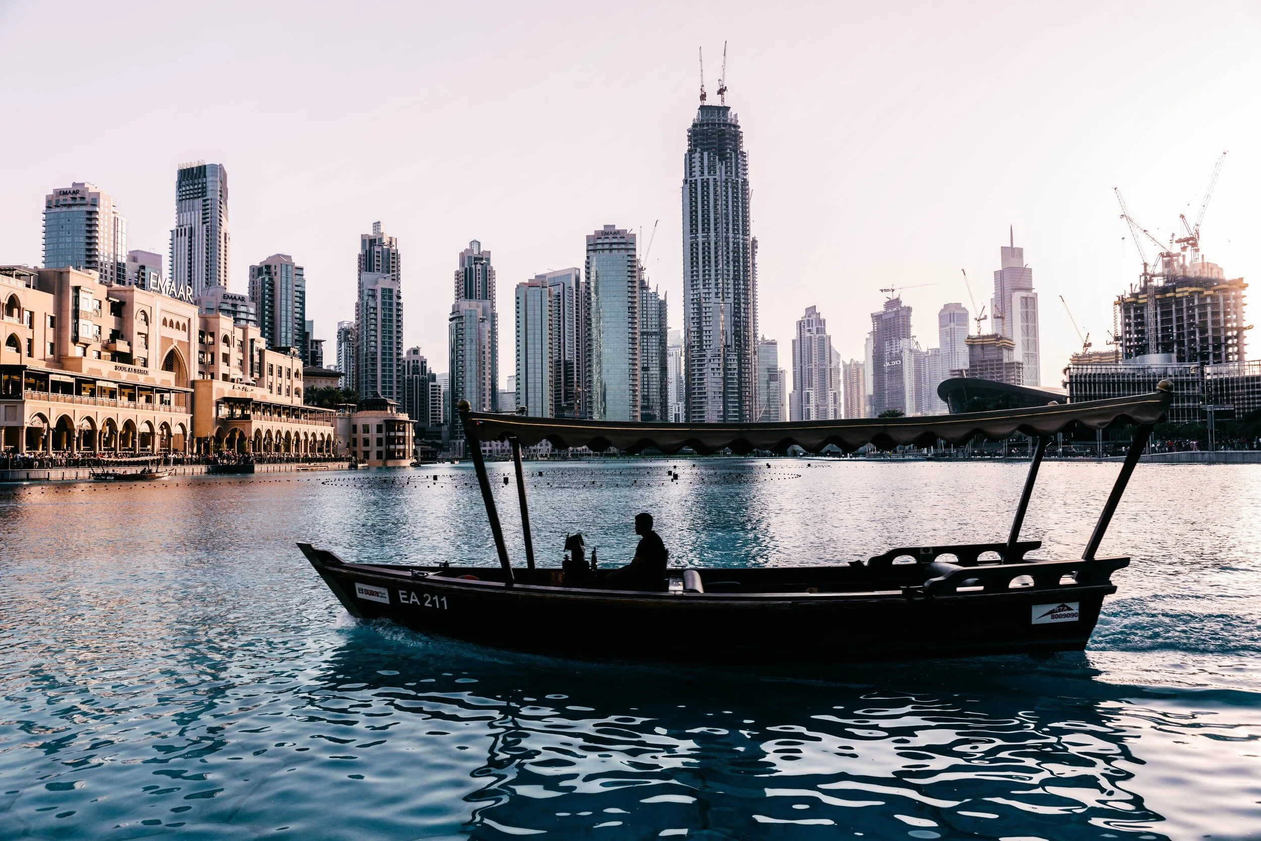 A boat on a river canal in dubai at sunset.