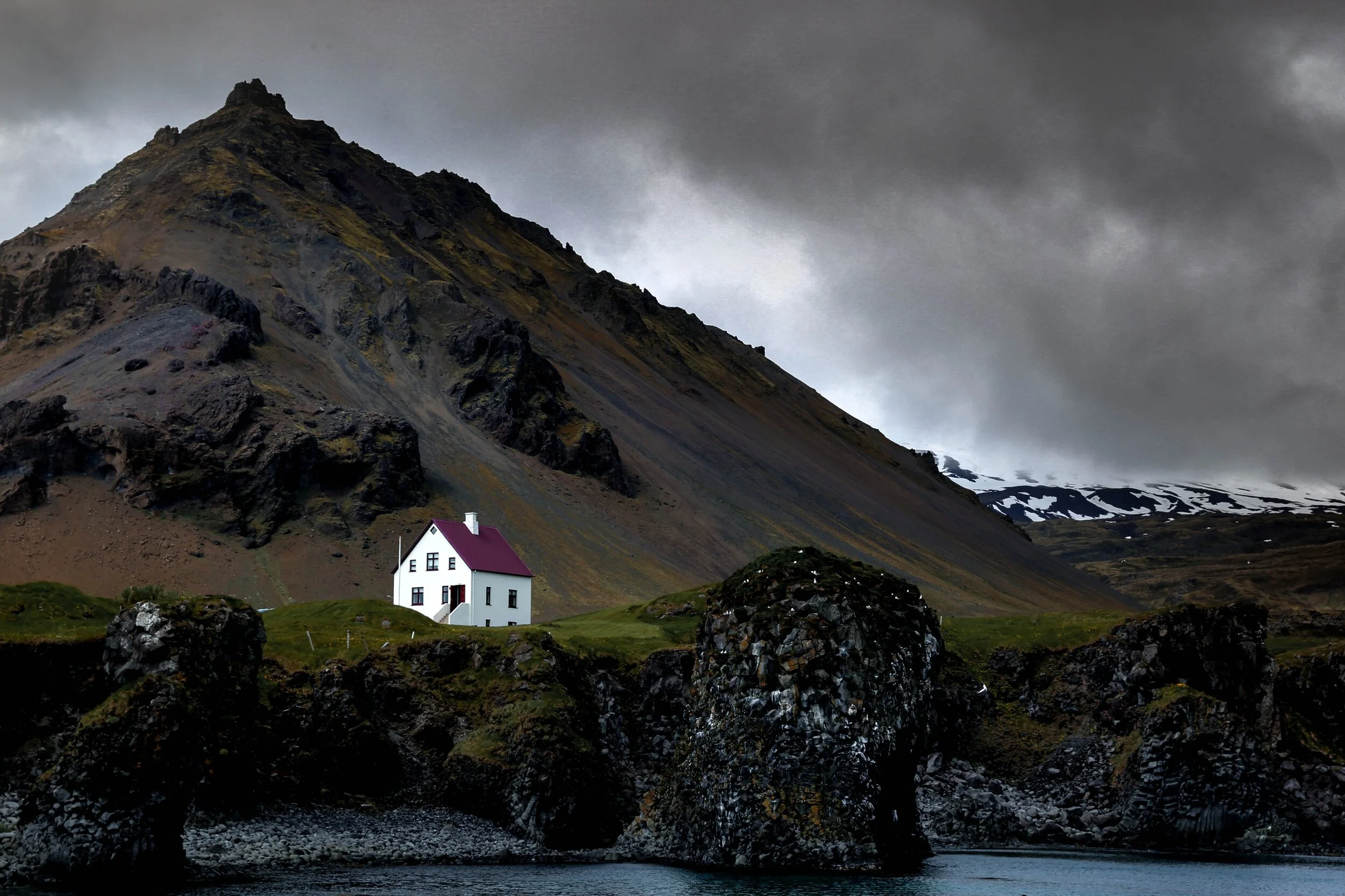 A white house on a secluded cliffside in Iceland.