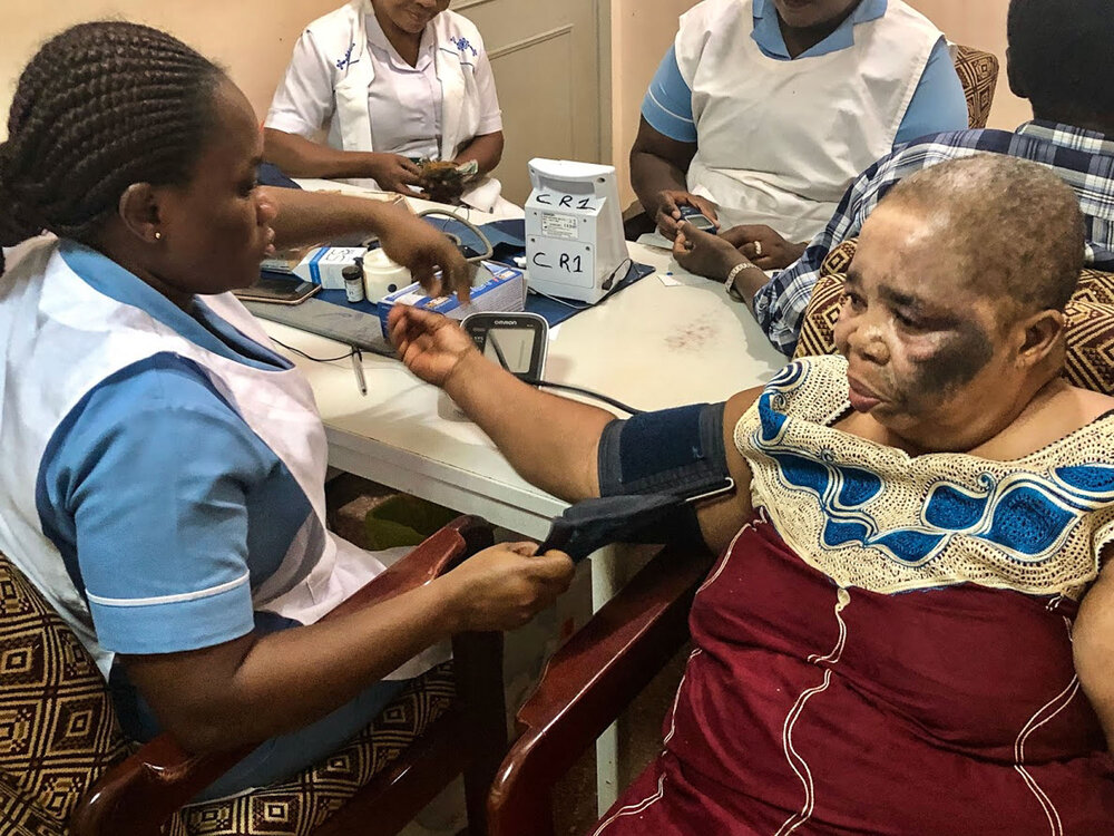 Community health worker assesses patient's blood pressure during ADHINCRA research in February 2019. Kumasi, Ghana. 