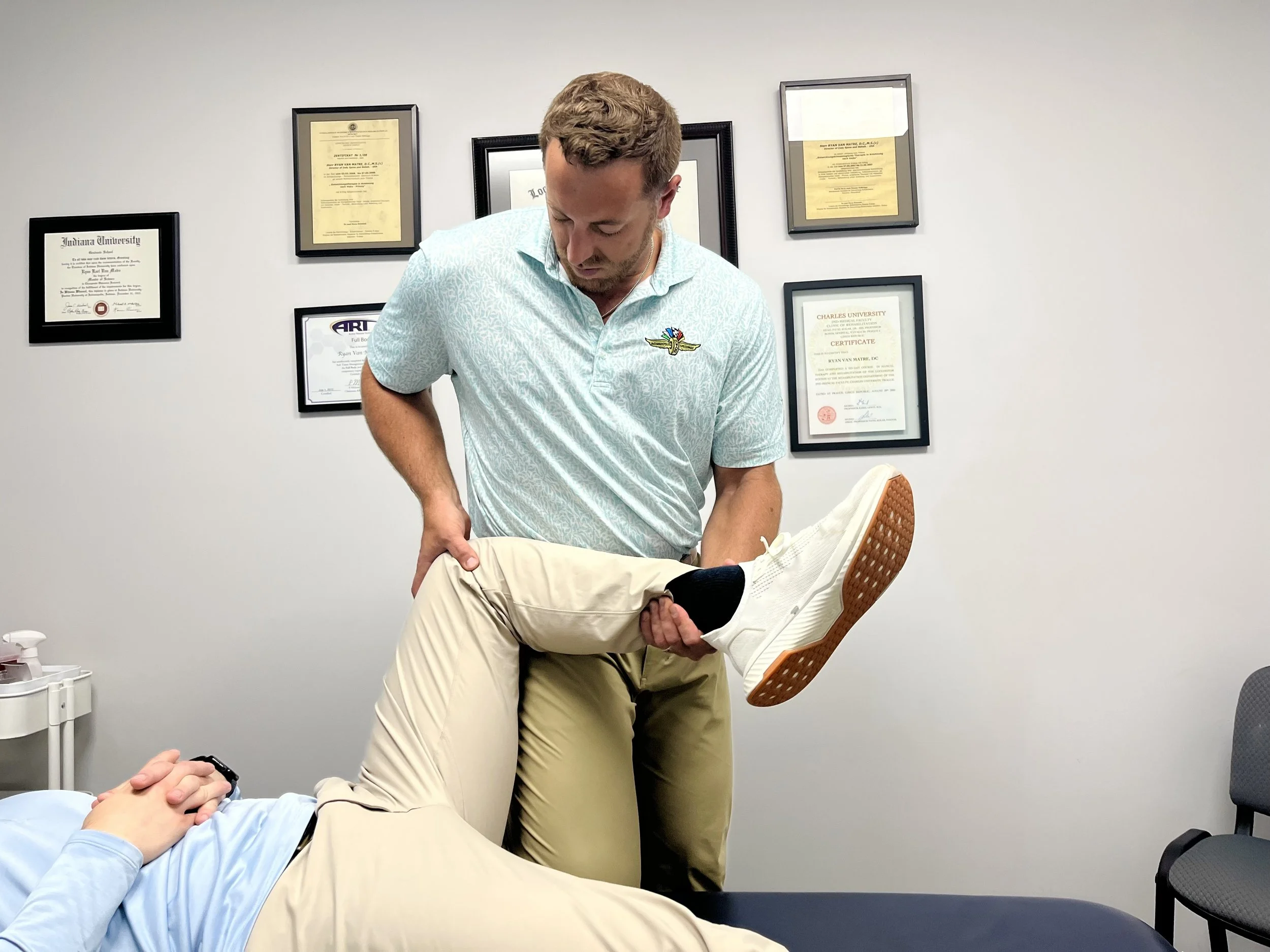 Sports chiropractor Dr. Alex Sarpa applying Active Release Technique (ART) and soft tissue scraping for knee pain relief at Indy Spine and Rehab.