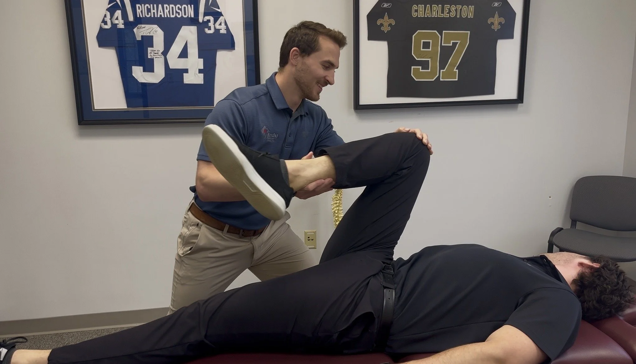 Sports chiropractor Dr. Brian Fuller performing Active Release Technique (ART) on a patient's hip and gluteal muscles for local pain relief in Carmel, Indiana.
