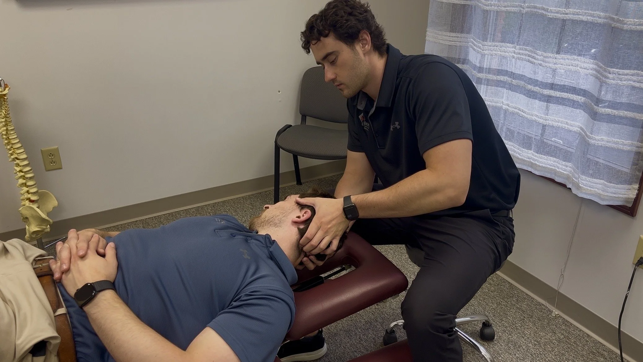 Sports chiropractor Dr. Owen Friest applying Active Release Technique (ART) to the cervical spine for tension headache and migraine relief in Carmel, Indiana.