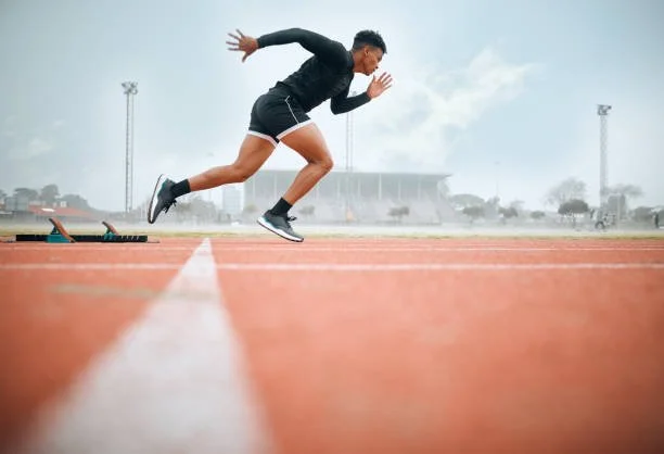 A runner sprinting on a track, representing sports chiropractic care and running injury rehabilitation at Indy Spine and Rehab in Carmel, Indiana.