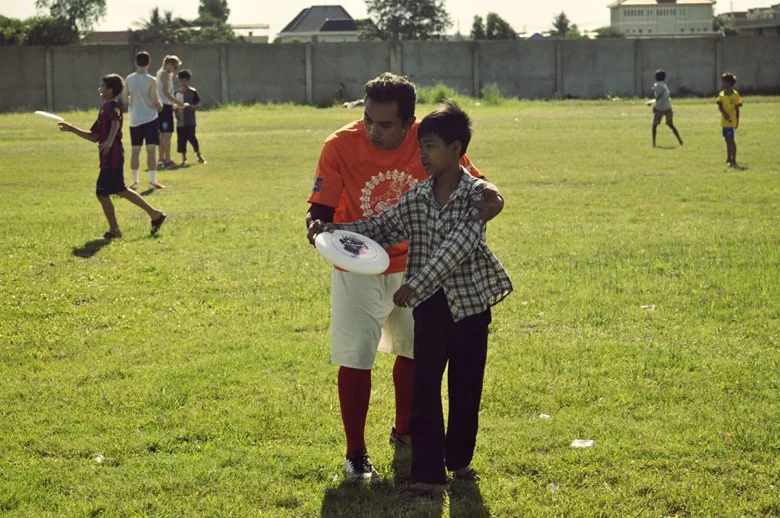 A YUP coach taking time to teach a camper how to properly throw a frisbee
