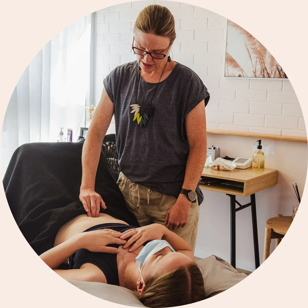 Liz, Pelvic Health Physiotherapist performs an abdominal examination on a patient in a clinical setting