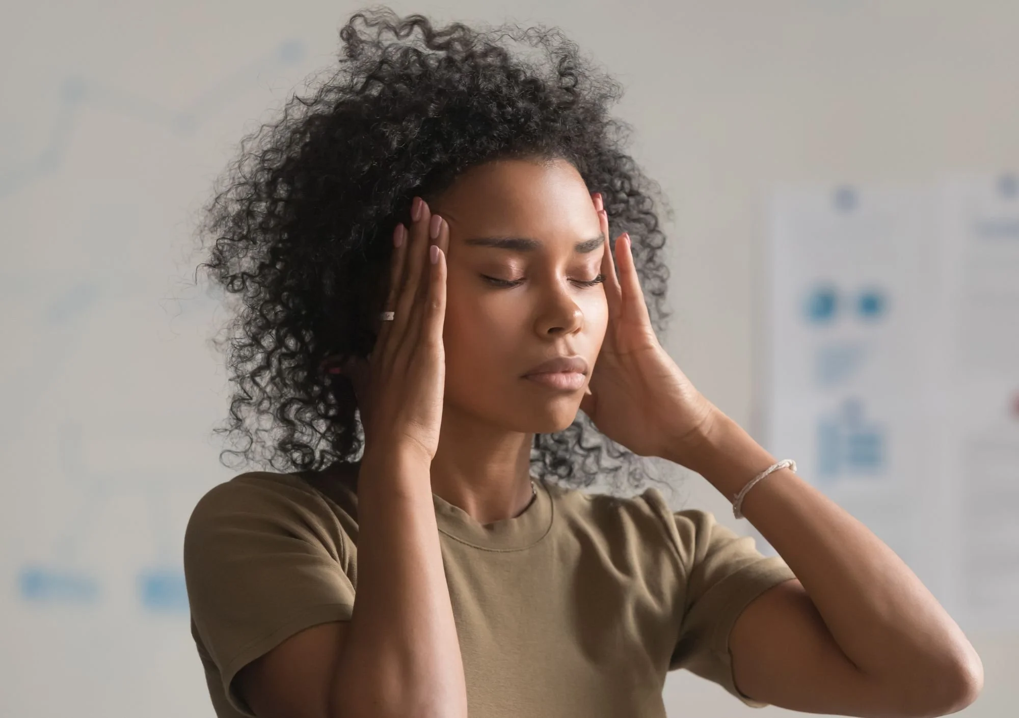 Women holding head, as though she is in pain with a headache