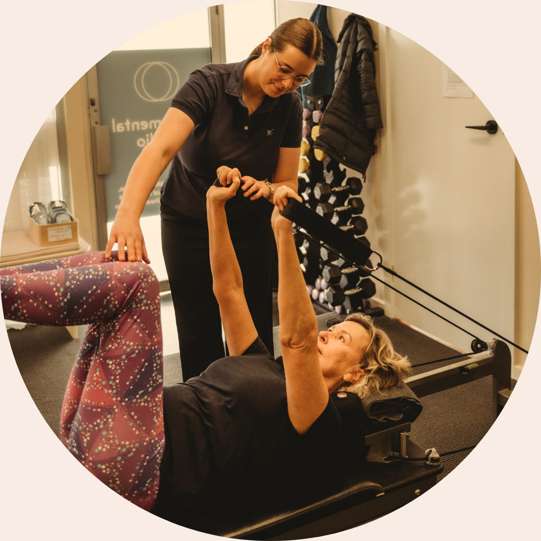 Women’s health Clinical Pilates session led by a physiotherapist, providing hands-on guidance during a personalised reformer Pilates exercise in Canberra.
