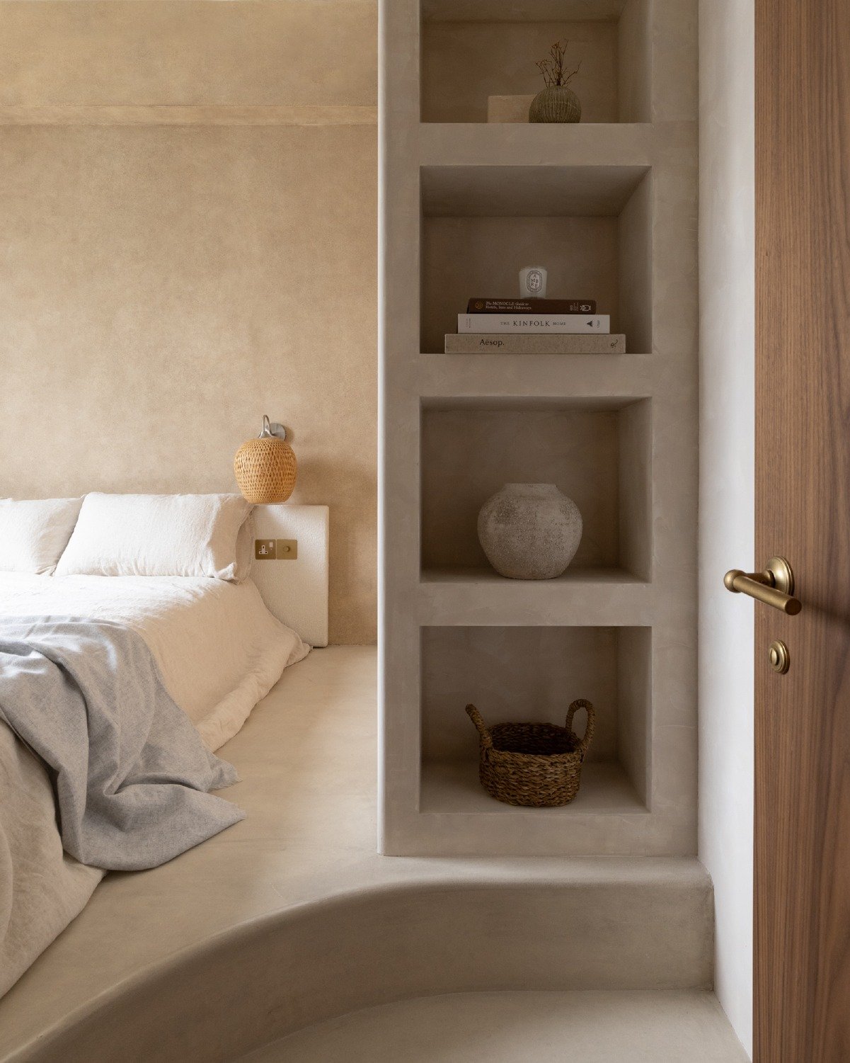 Transitioning through a dome shaped portal, one arrives at the master bedroom where a bespoke display shelf greets you upon entry. Set on a raised platform against a woven velvet fabric headboard, the bed was designed to maximise both storage and com