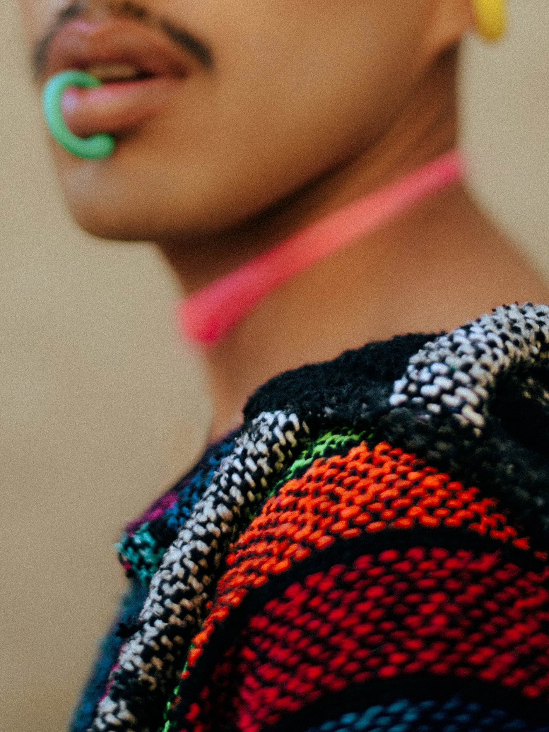 Close-up of a person wearing colorful clothing, with a lip piercing and a pink choker, and part of their face showing a lip and nose, photographed during a fashion editorial photography session in Los Angeles with fashion photographer Gí Tenamá..