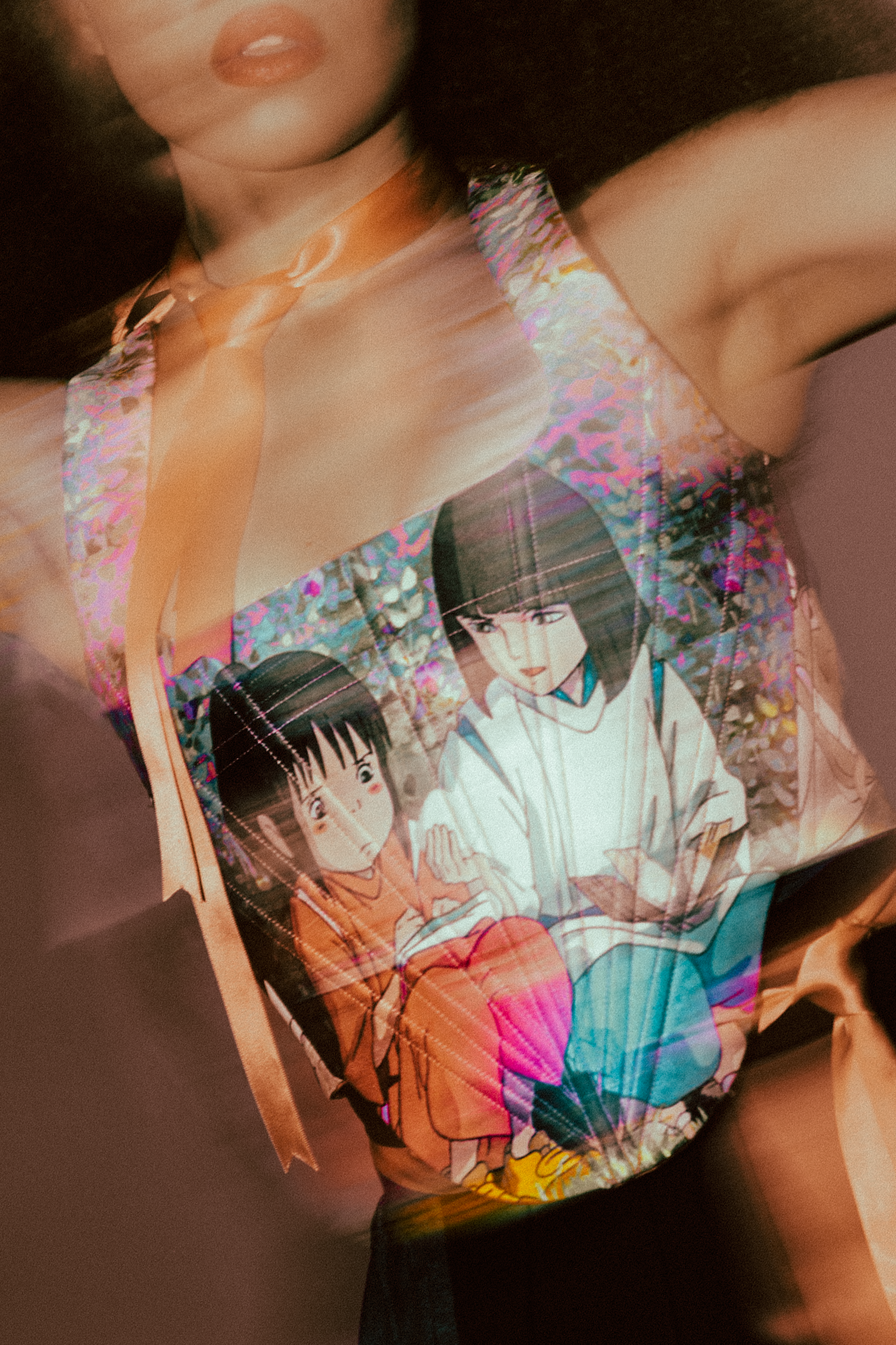 A sleeveless top featuring characters from an anime called Spirited Away, against a pink background, photographed during a fashion editorial photography session in Los Angeles with fashion photographer Gí Tenamá..