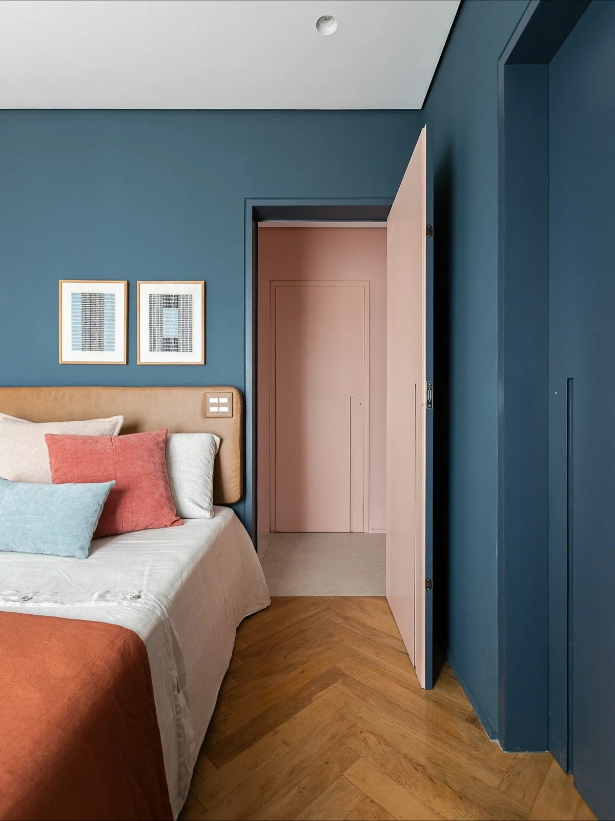 DS Ap Vila Madalena JG &bull; 

No quarto de h&oacute;spedes sugerimos uma cama sob medida, com cabeceria estofada em couro. J&aacute; esse azul lindo chama Azul Borracha da @tintas_suvinil e contrastou perfeitamente com o corredor rosa e o banheiro 